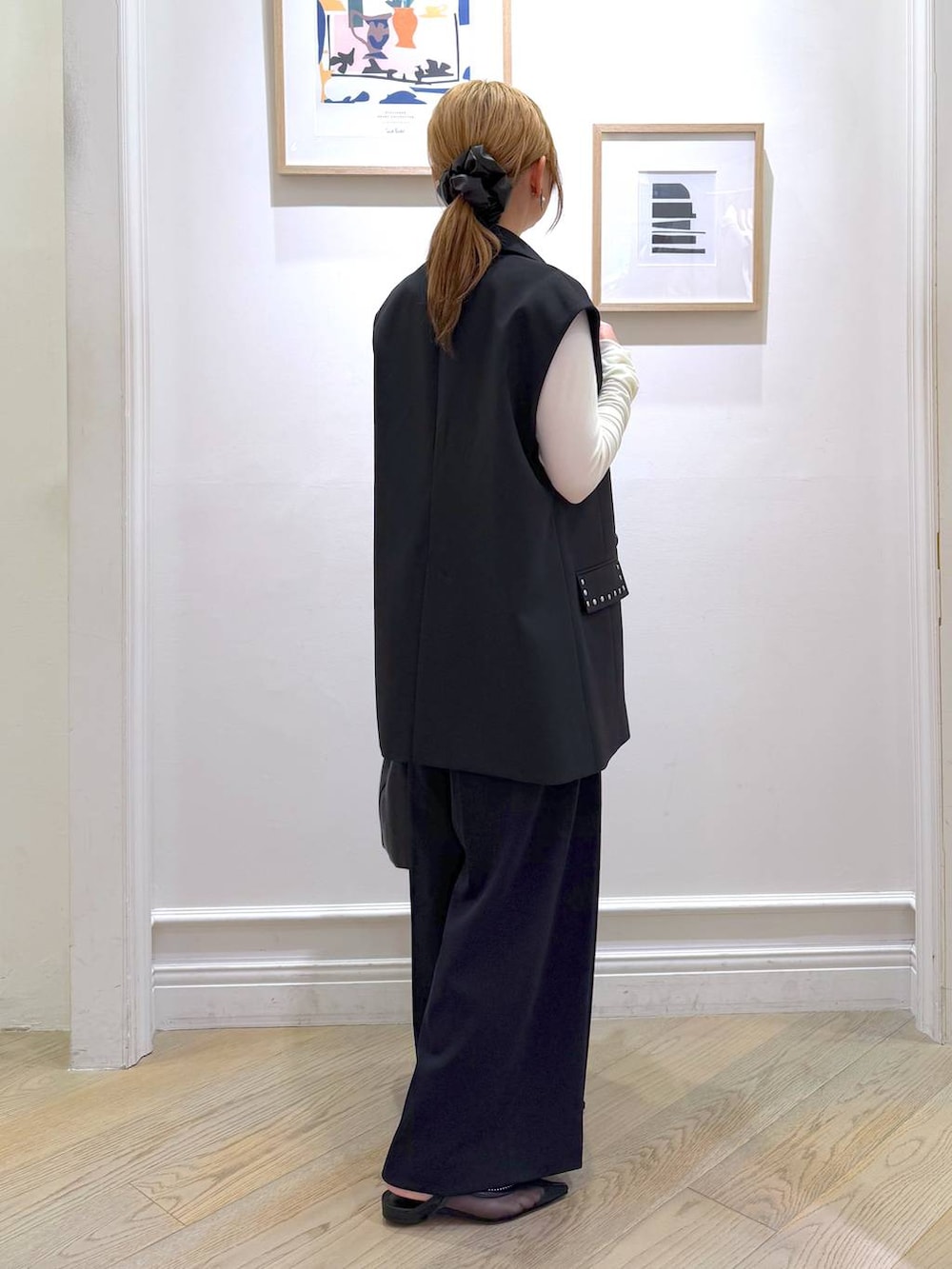 ブラック系のベスト、ブラック系のスラックス、ホワイト系のTシャツ/カットソーを着用したレディースの冬コーディネートの7枚目の写真