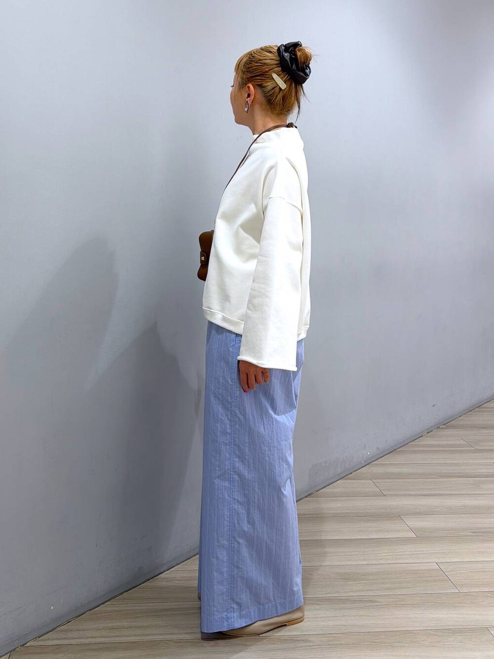 ホワイト系のスウェット、ブルー系のその他パンツ、ブラウン系のその他小物を着用したレディースの冬コーディネートの2枚目の写真