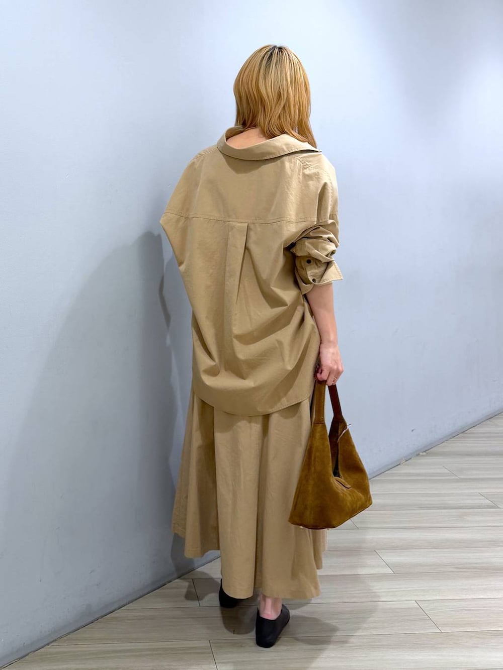 ブラウン系のハンドバッグ、ブラック系のパンプス、ベージュ系のスカートを着用したレディースの春コーディネートの4枚目の写真