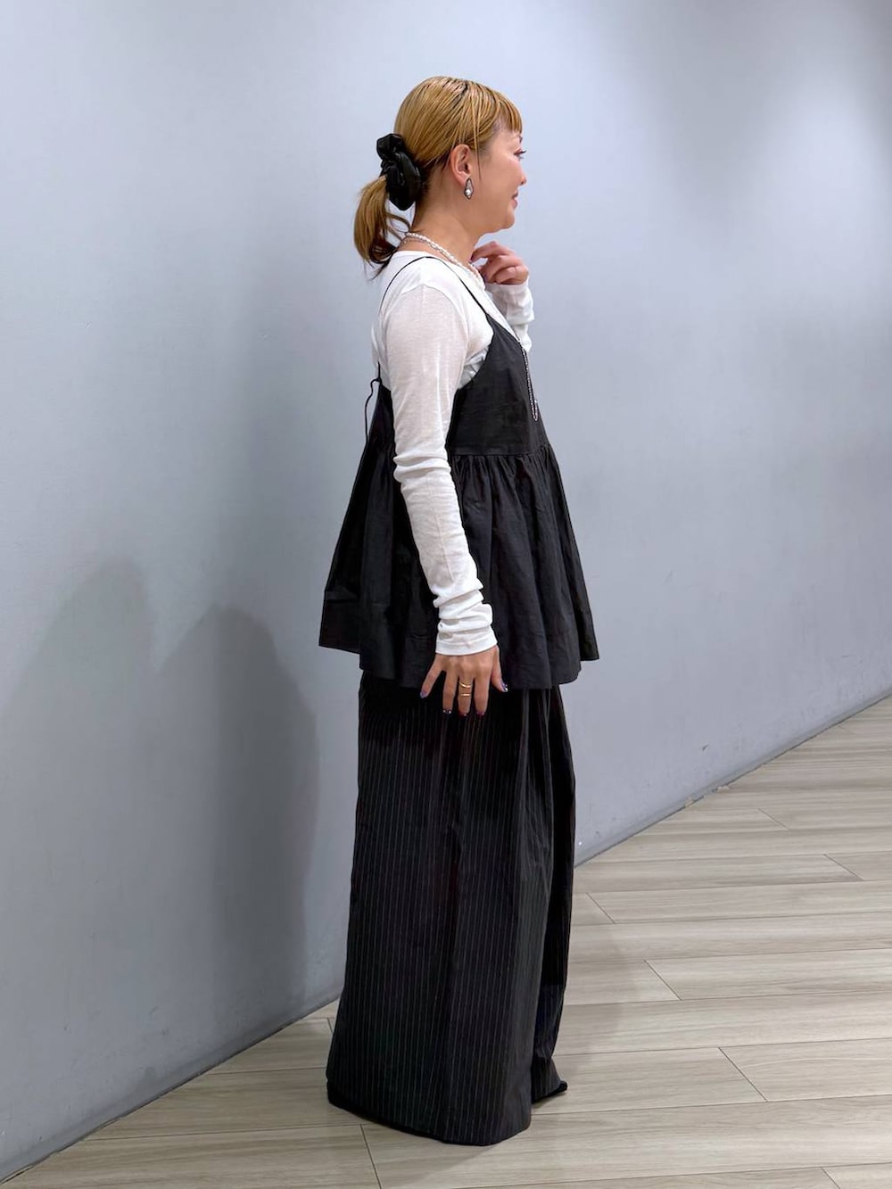 ブルー系のハンドバッグ、ホワイト系のTシャツ/カットソー、グレー系のキャミソールを着用したレディースの冬コーディネートの2枚目の写真