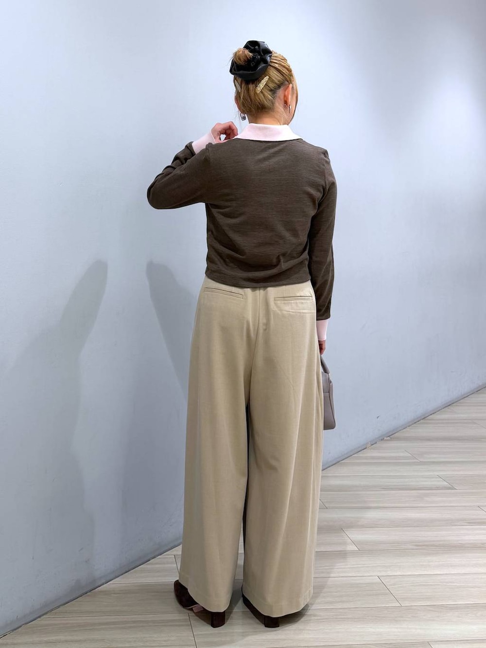 ベージュ系のボストンバッグ、ベージュ系のその他パンツ、ブラウン系のポロシャツを着用したレディースの冬コーディネートの4枚目の写真