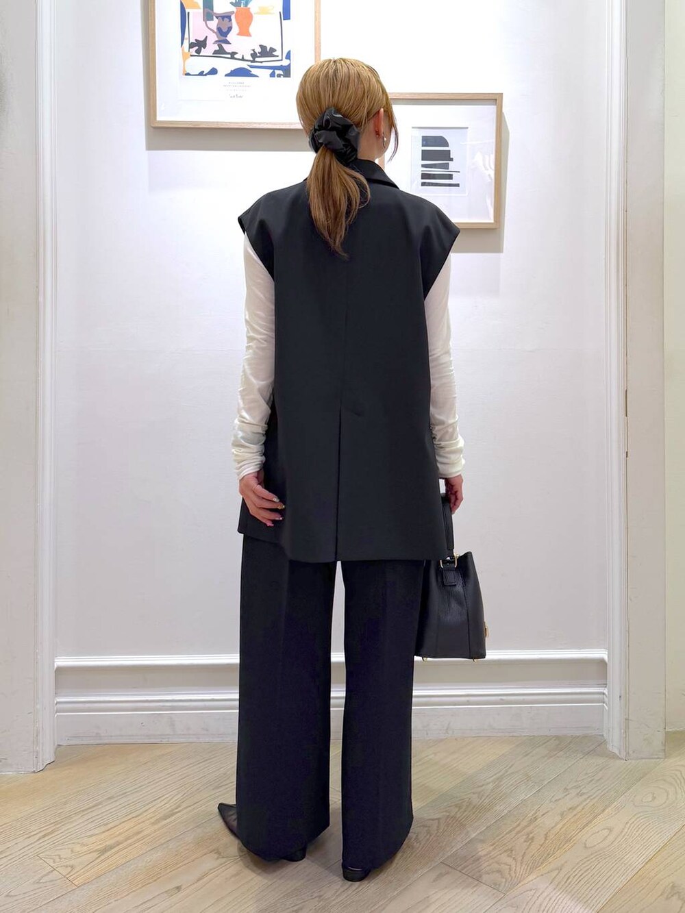 ブラック系のベスト、ブラック系のスラックス、ホワイト系のTシャツ/カットソーを着用したレディースの冬コーディネートの5枚目の写真