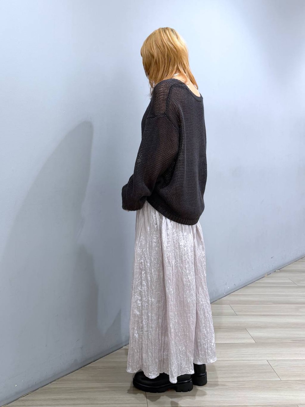 ブラック系のブーツ、ブラック系のボストンバッグ、シルバー系のスカートを着用したレディースの春コーディネートの4枚目の写真