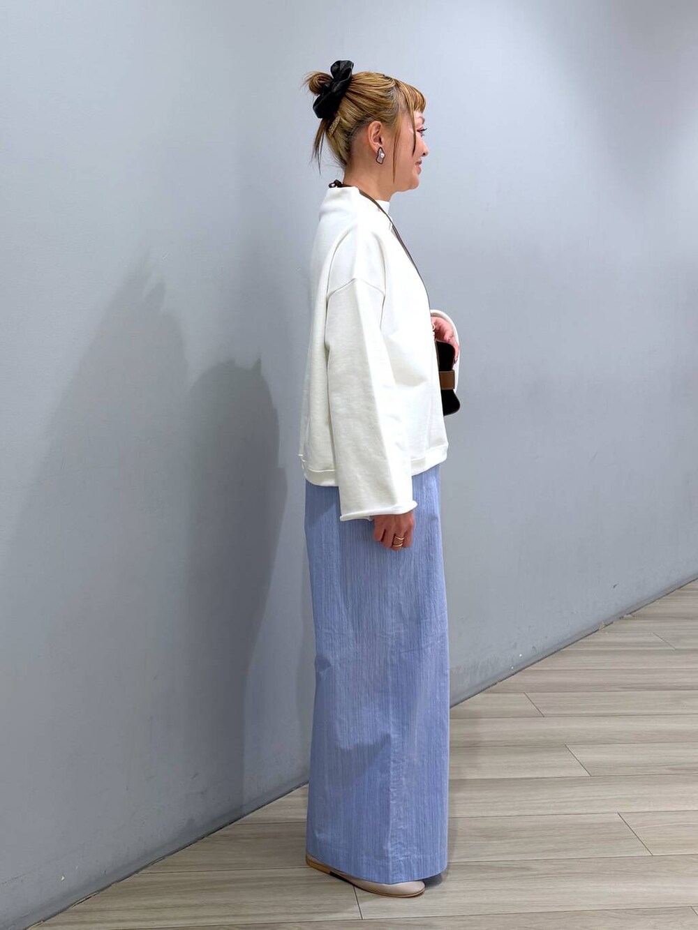 ホワイト系のスウェット、ブルー系のその他パンツ、ブラウン系のその他小物を着用したレディースの冬コーディネートの3枚目の写真