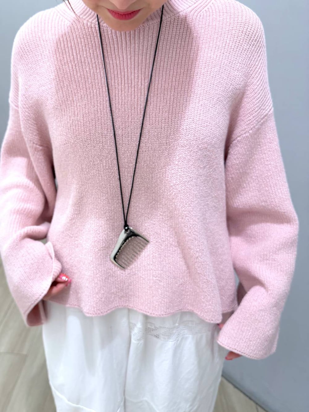 ピンク系のニット/セーターを着用したレディースの冬コーディネートの7枚目の写真