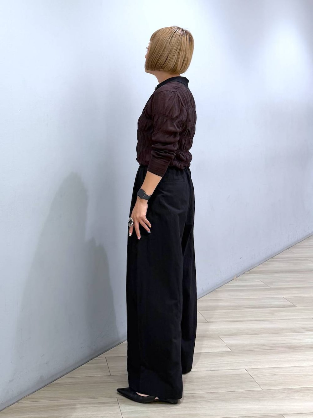 ブラウン系のポロシャツ、ブラック系のその他パンツ、ブラウン系のハンドバッグを着用したレディースの秋コーディネートの3枚目の写真