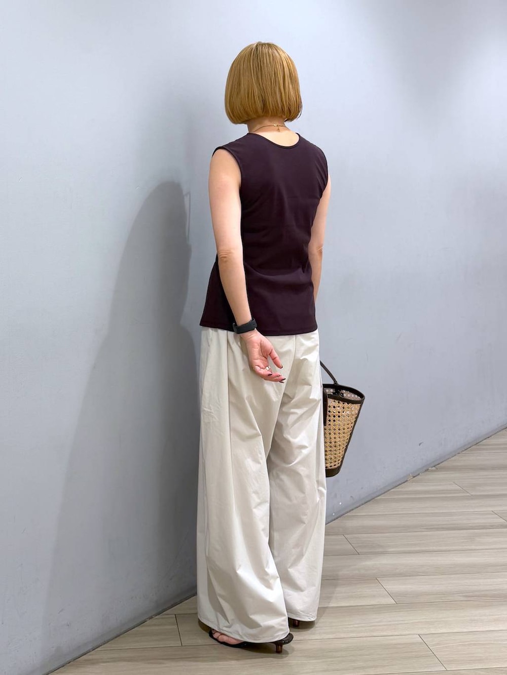ベージュ系のかごバッグ、ホワイト系のその他パンツ、ブラウン系のニット/セーターを着用したレディースの夏コーディネートの2枚目の写真