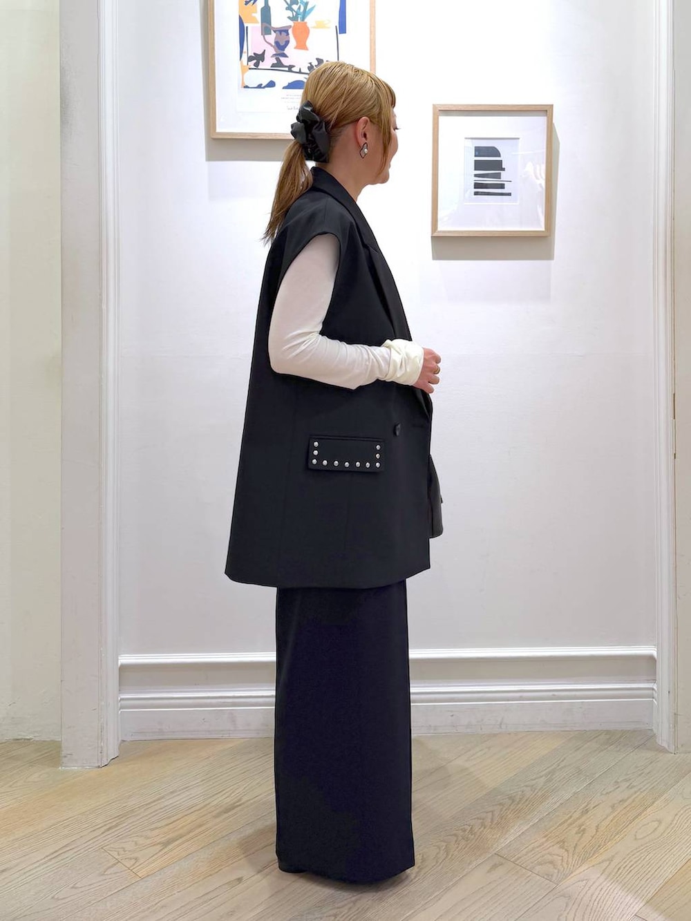 ブラック系のベスト、ブラック系のスラックス、ホワイト系のTシャツ/カットソーを着用したレディースの冬コーディネートの6枚目の写真