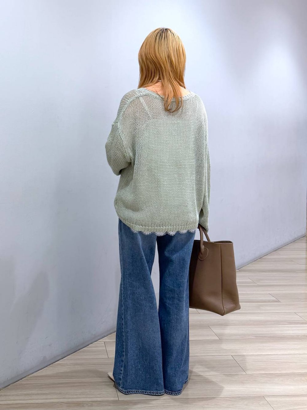 ベージュ系のパンプス、ブルー系のデニムパンツ、ホワイト系のキャミソールを着用したレディースの春コーディネートの7枚目の写真