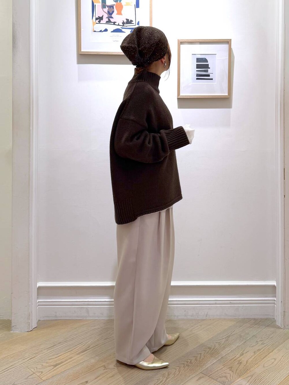 ベージュ系のその他パンツ、ゴールド系のパンプス、ブラウン系のニット/セーターを着用したレディースの冬コーディネートの2枚目の写真