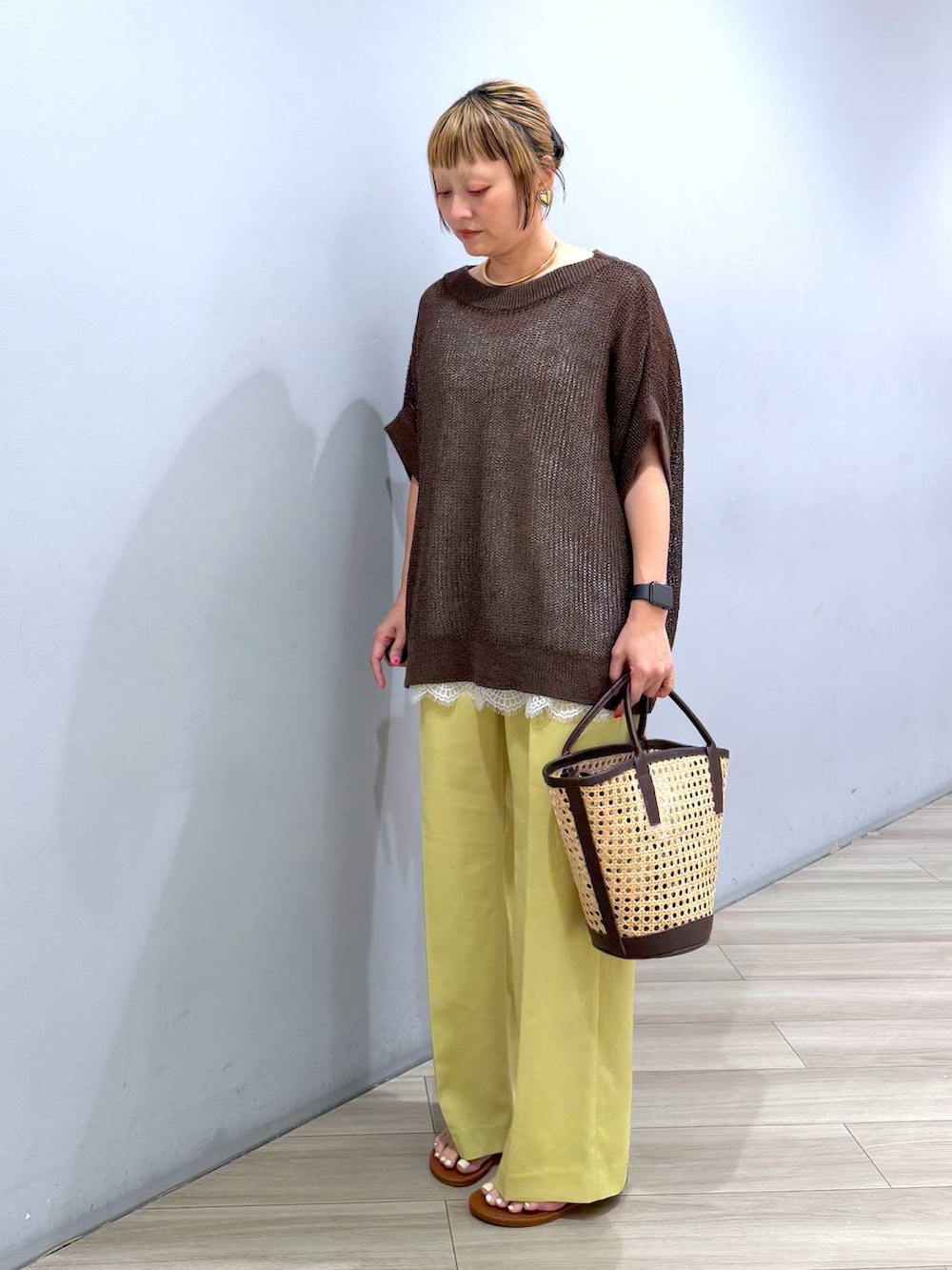 ブラウン系のTシャツ/カットソー、ホワイト系のキャミソール、イエロー系のスラックスを着用したレディースの春コーディネートの5枚目の写真