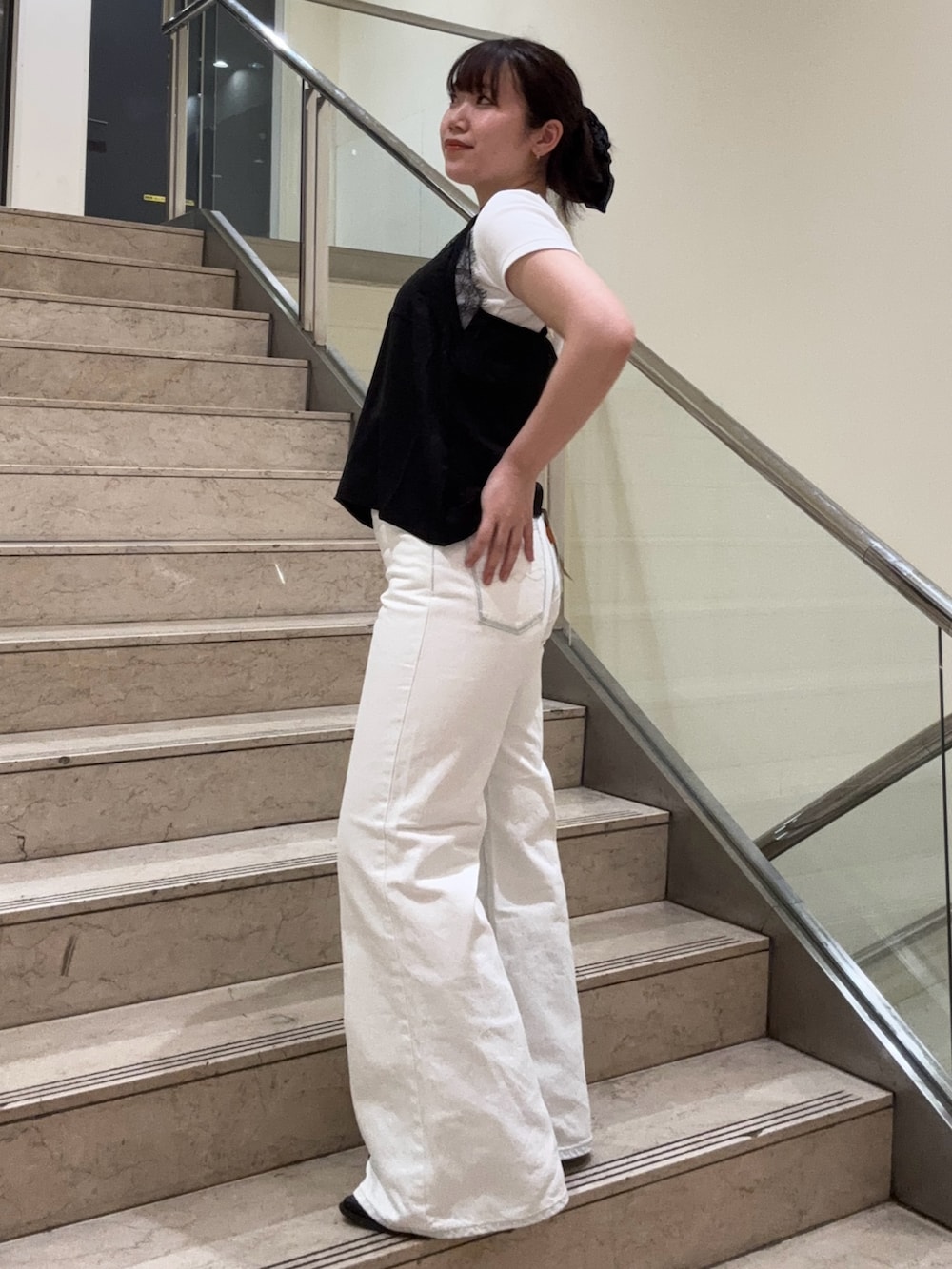 ホワイト系のデニムパンツ、ブラック系のブーツ、ブラック系のキャミソールを着用したレディースの春コーディネートの2枚目の写真
