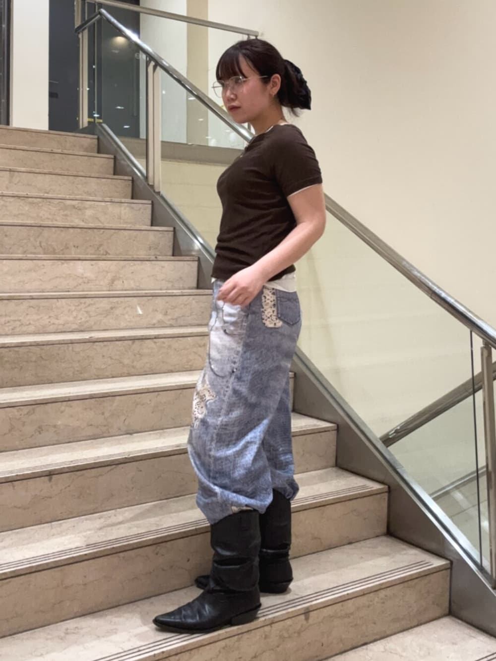 ブラック系のブーツ、ブルー系のデニムパンツ、ブラウン系のTシャツ/カットソーを着用したレディースの夏コーディネートの2枚目の写真