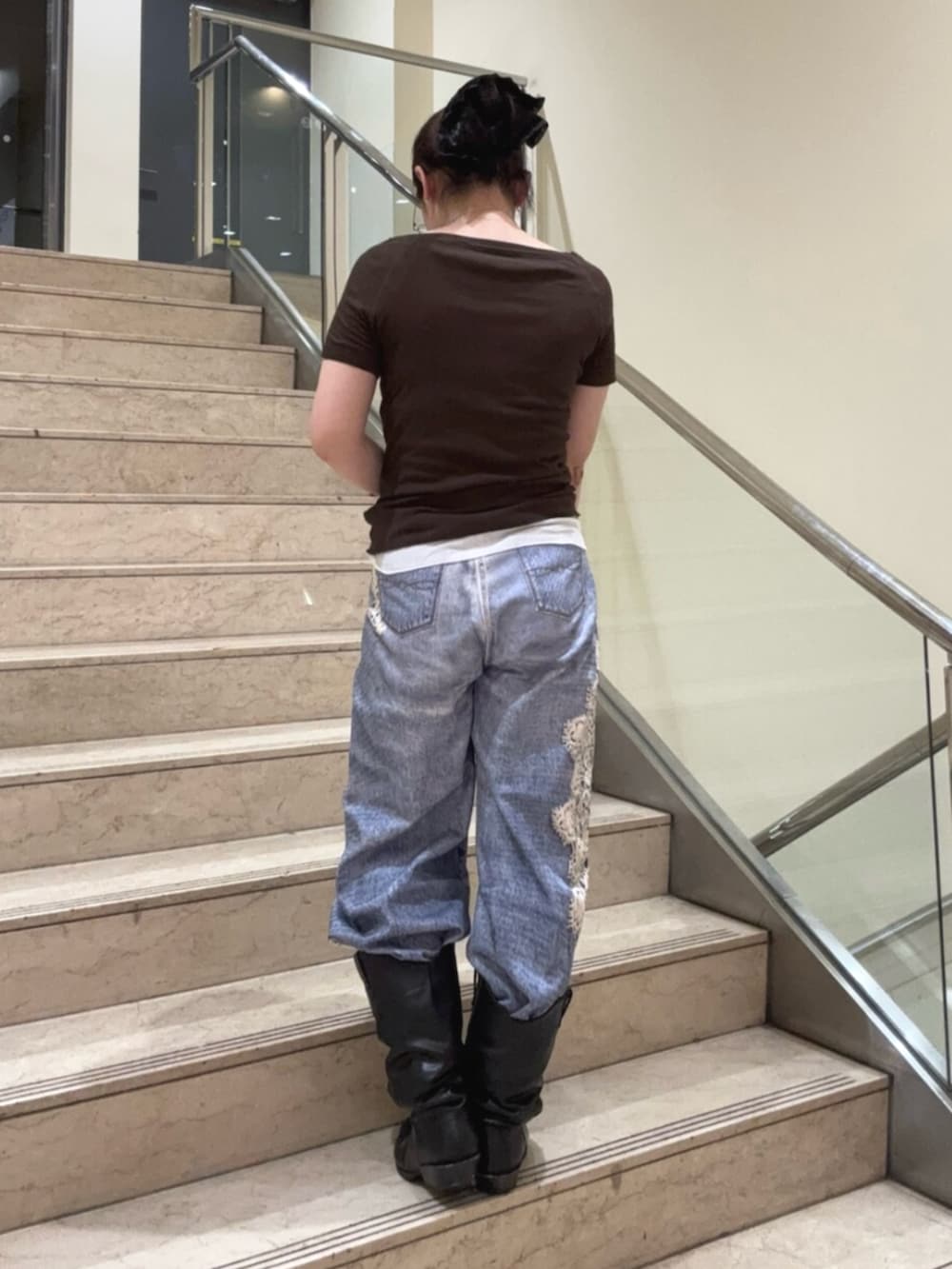ブラック系のブーツ、ブルー系のデニムパンツ、ブラウン系のTシャツ/カットソーを着用したレディースの夏コーディネートの3枚目の写真
