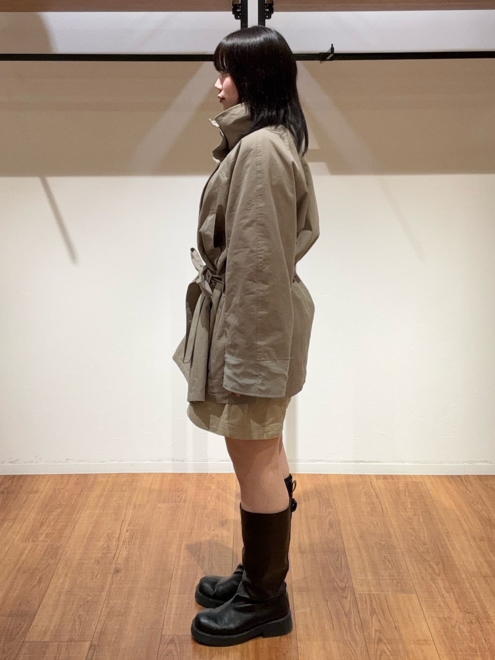 ベージュ系のその他パンツ、グリーン系のトレンチコート、ブラック系のブーツを着用したレディースの春コーディネートの5枚目の写真