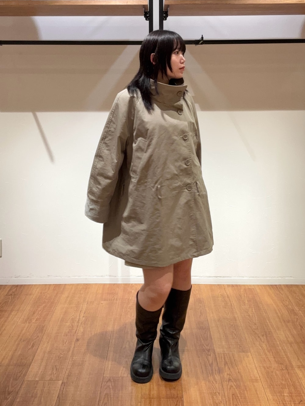 ベージュ系のその他パンツ、グリーン系のトレンチコート、ブラック系のブーツを着用したレディースの春コーディネートの3枚目の写真