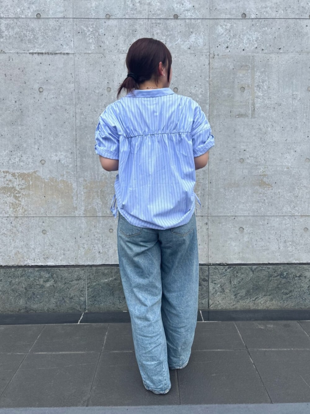 ホワイト系のパンプス、ブルー系のシャツ/ブラウス、ブルー系のデニムパンツを着用したレディースの夏コーディネートの3枚目の写真