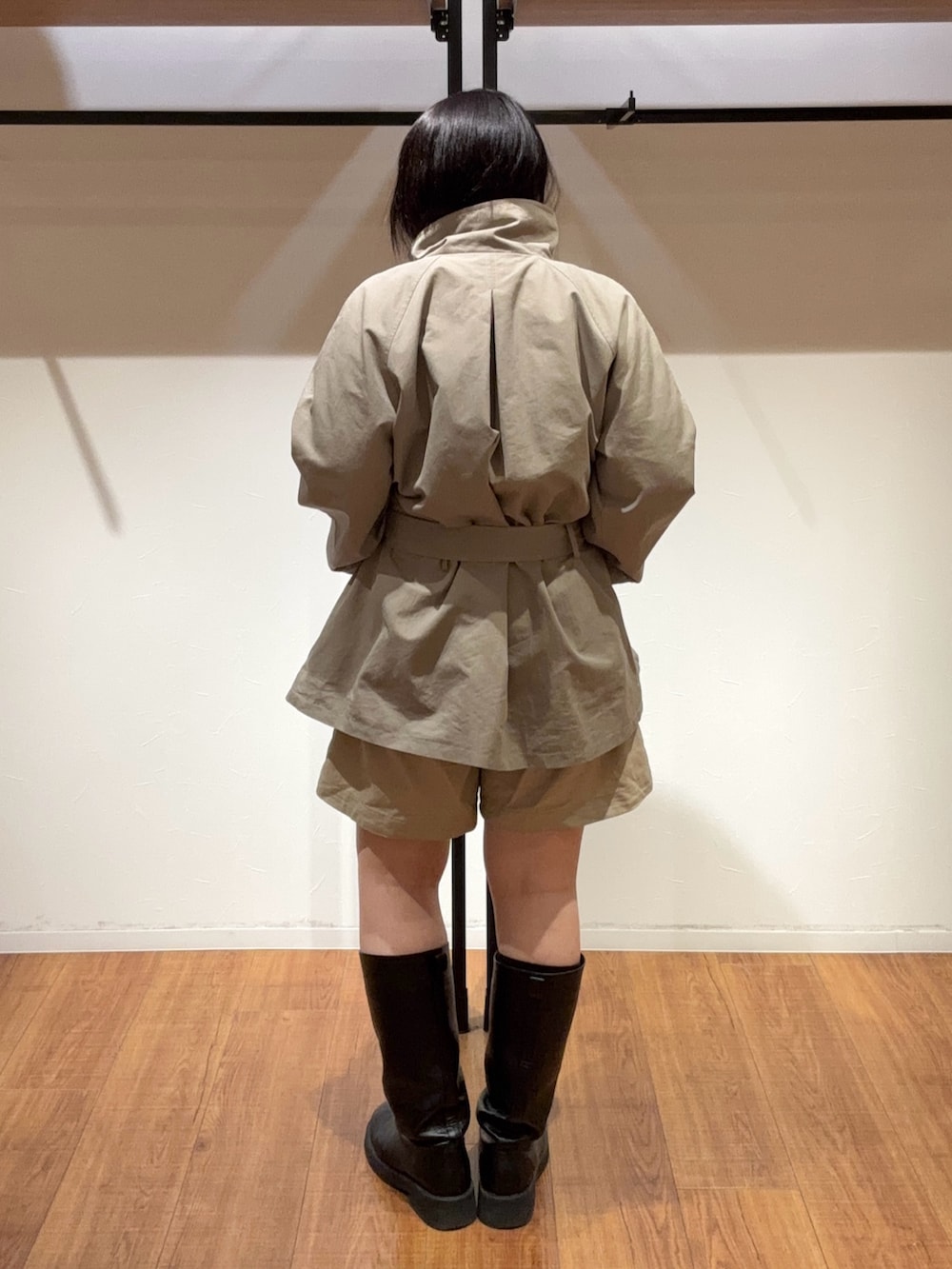 ベージュ系のその他パンツ、グリーン系のトレンチコート、ブラック系のブーツを着用したレディースの春コーディネートの6枚目の写真