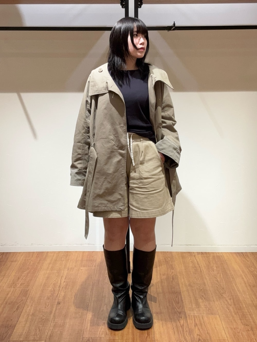 ベージュ系のその他パンツ、グリーン系のトレンチコート、ブラック系のブーツを着用したレディースの春コーディネートの2枚目の写真