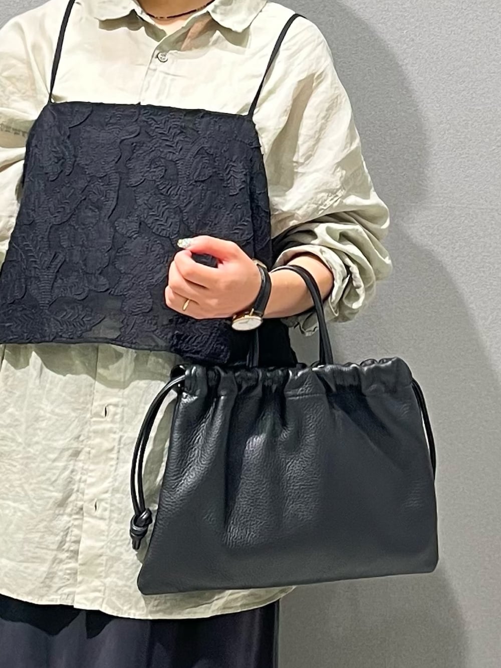 グリーン系のシャツ/ブラウス、ブラック系のキャミソール、ブラック系のスカートを着用したレディースの秋コーディネートの5枚目の写真