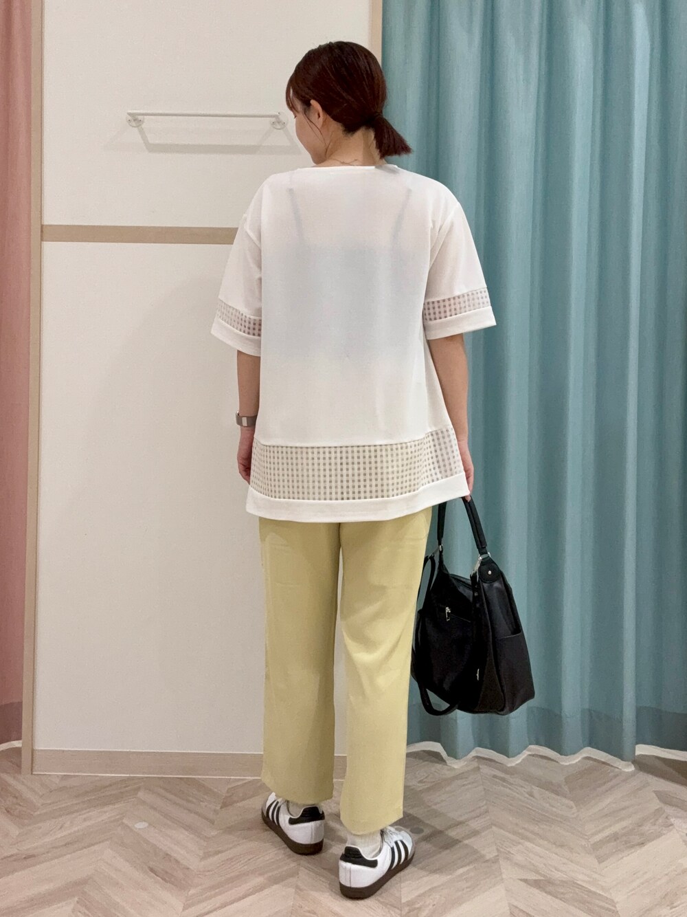 ホワイト系のチュニック、イエロー系のその他パンツ、ブラック系のショルダーバッグを着用したレディースの秋コーディネートの4枚目の写真