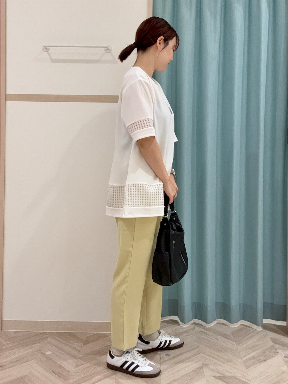 ホワイト系のチュニック、イエロー系のその他パンツ、ブラック系のショルダーバッグを着用したレディースの秋コーディネートの3枚目の写真