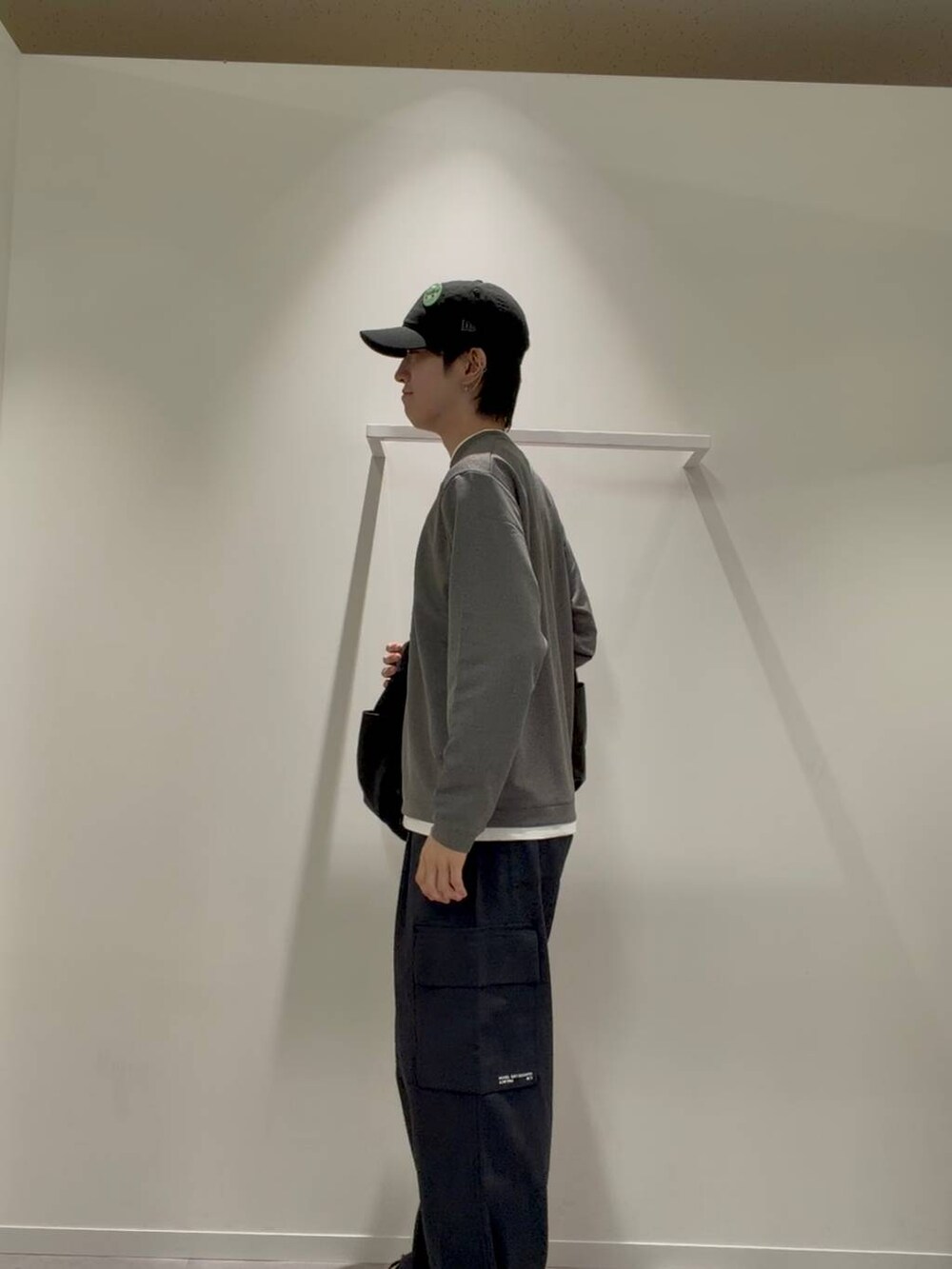 ブラック系のショルダーバッグ、グレー系のその他シューズ、ブルー系のデニムパンツを着用したメンズの秋コーディネートの3枚目の写真