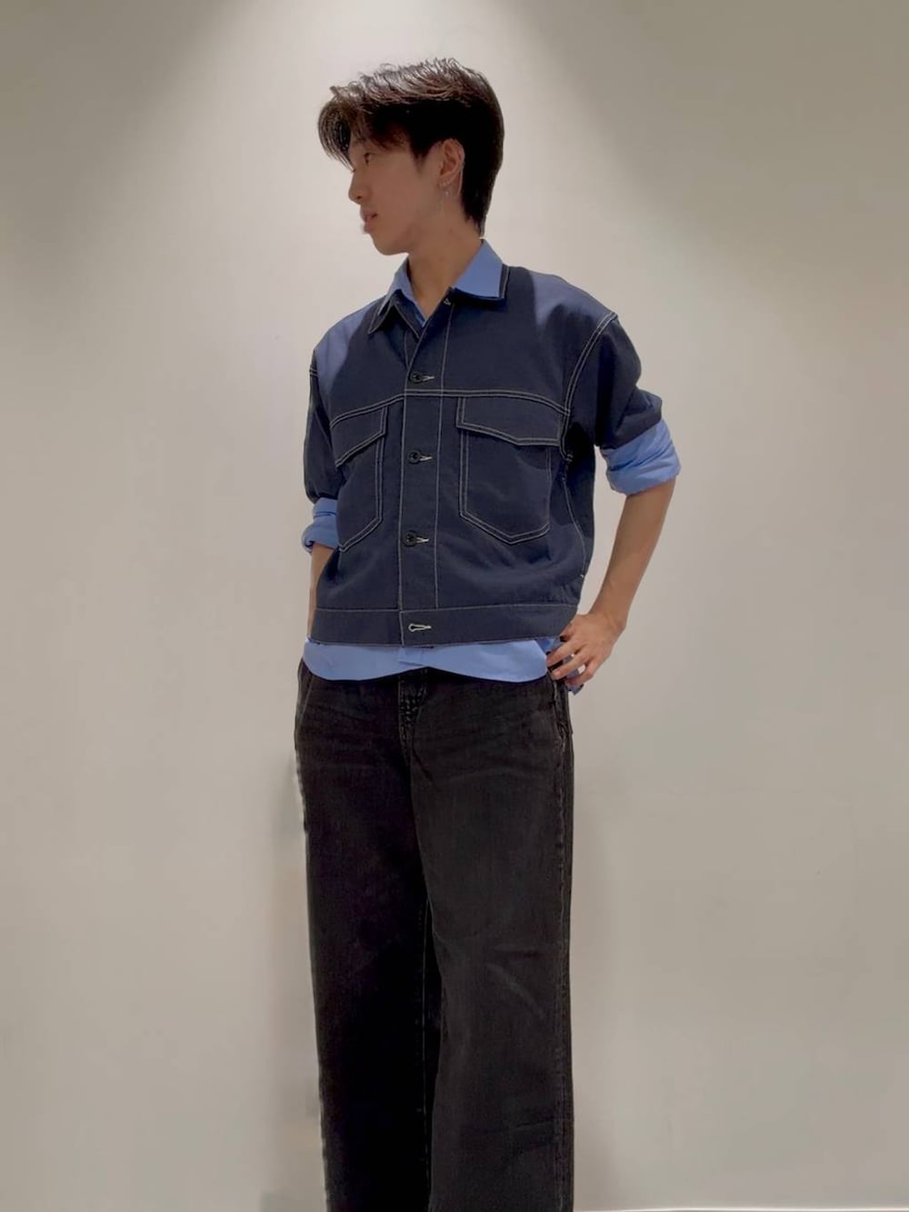 ブラック系のスニーカー、ブラック系のデニムパンツ、ブルー系のシャツ/ブラウスを着用したメンズの秋コーディネートの2枚目の写真