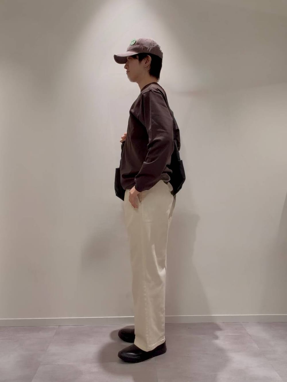 グレー系のその他シューズ、ホワイト系のその他パンツ、ブラック系のショルダーバッグを着用したメンズの秋コーディネートの4枚目の写真