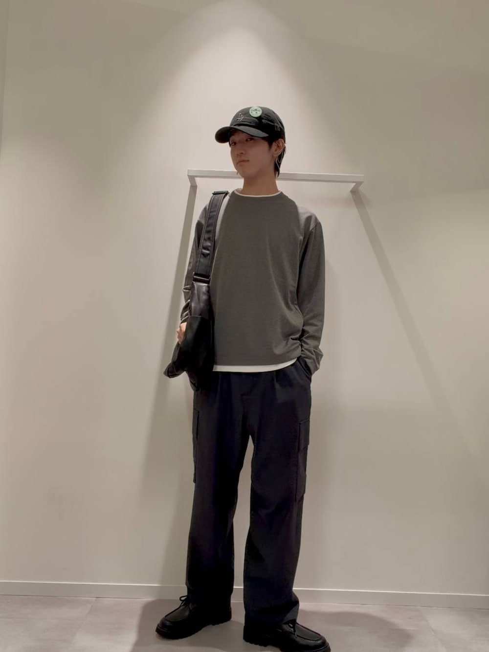 ブラック系のショルダーバッグ、グレー系のその他シューズ、ブルー系のデニムパンツを着用したメンズの秋コーディネートの2枚目の写真