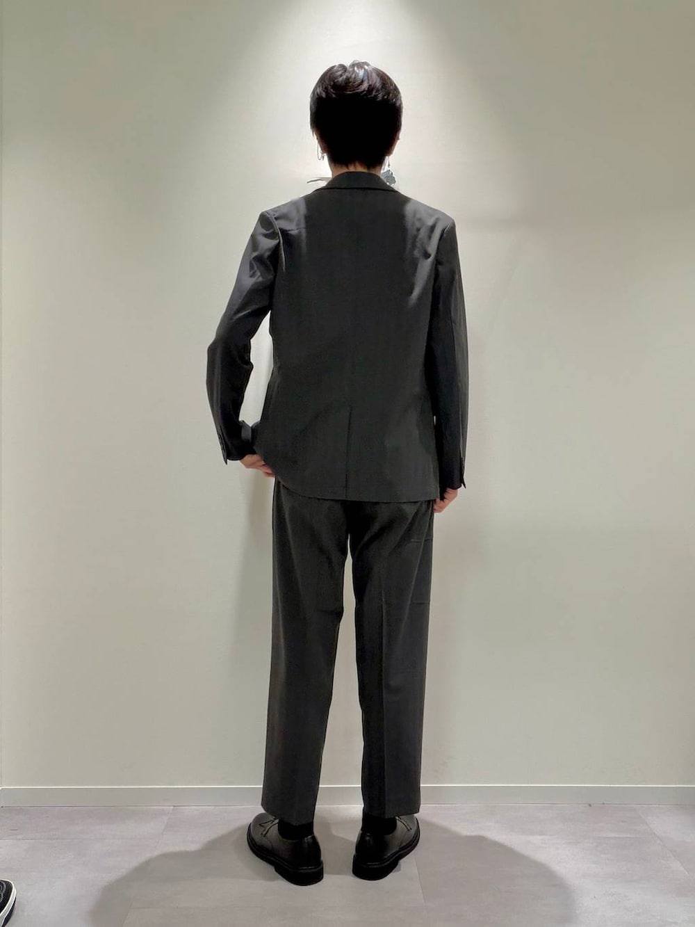 グレー系のスラックス、ブラック系のその他シューズ、ホワイト系のTシャツ/カットソーを着用したメンズの夏コーディネートの3枚目の写真