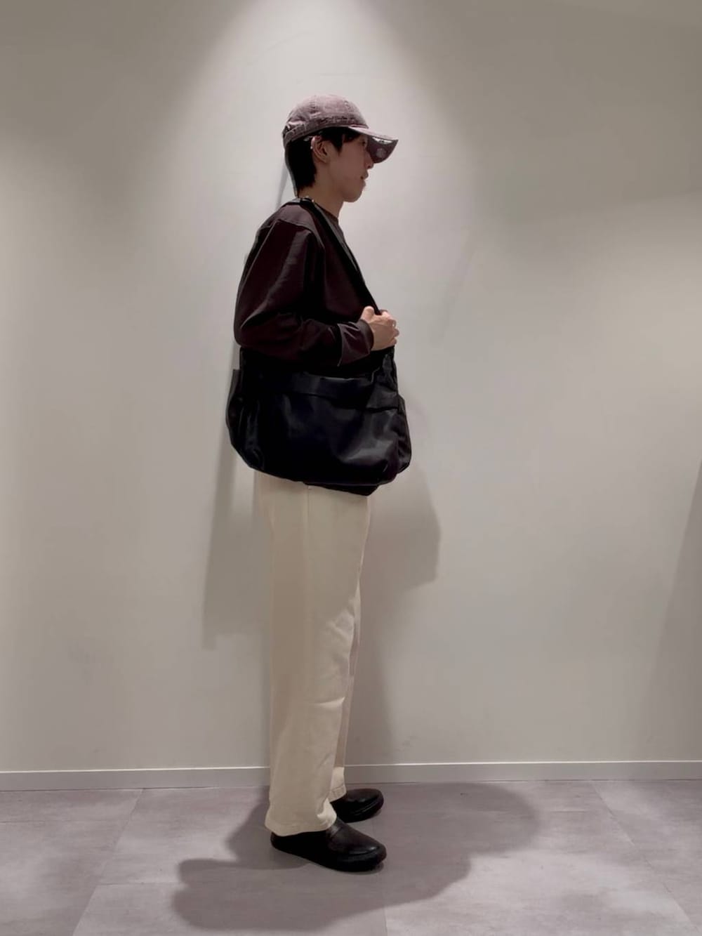 グレー系のその他シューズ、ホワイト系のその他パンツ、ブラック系のショルダーバッグを着用したメンズの秋コーディネートの2枚目の写真