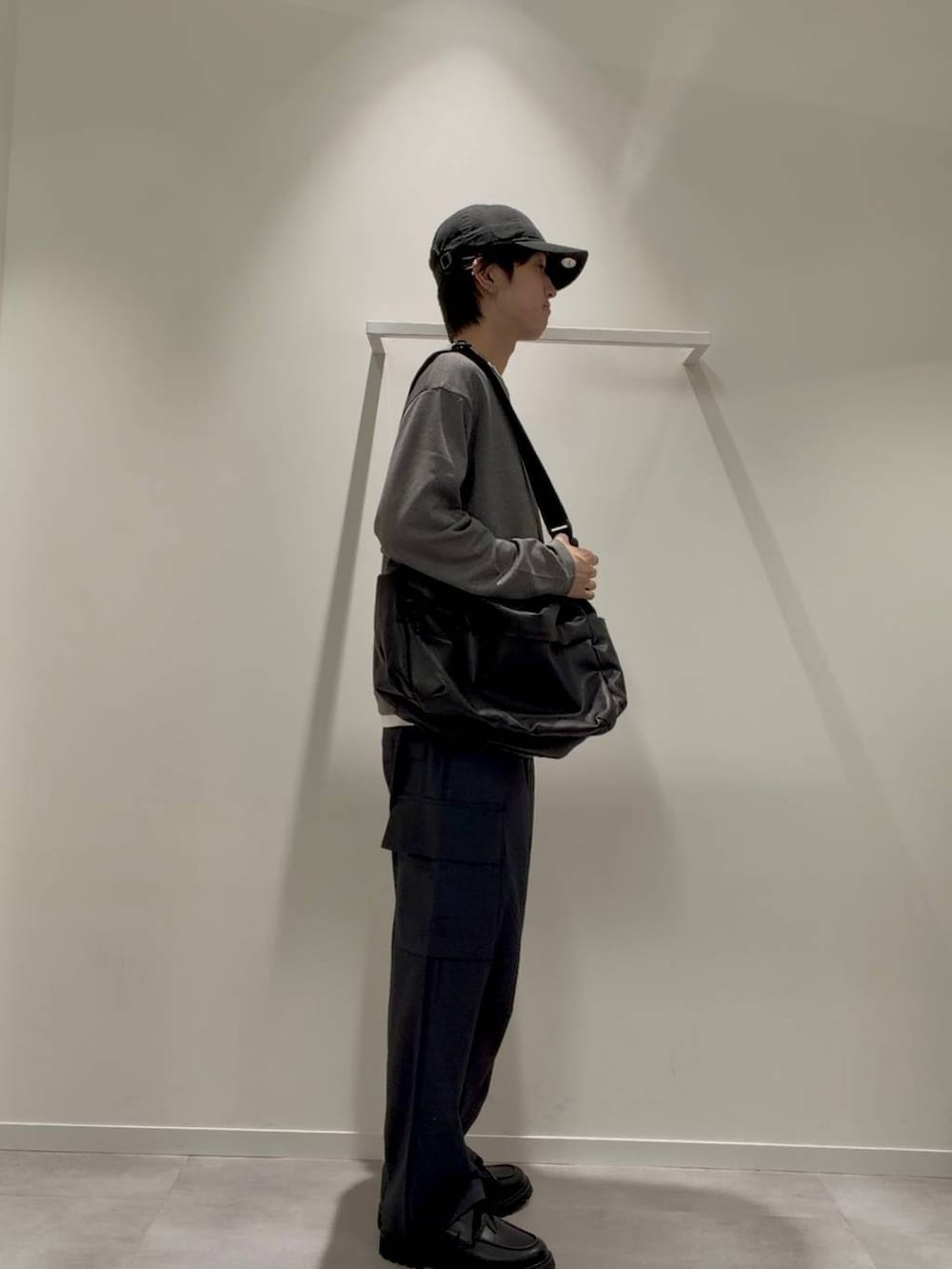 ブラック系のショルダーバッグ、グレー系のその他シューズ、ブルー系のデニムパンツを着用したメンズの秋コーディネートの5枚目の写真
