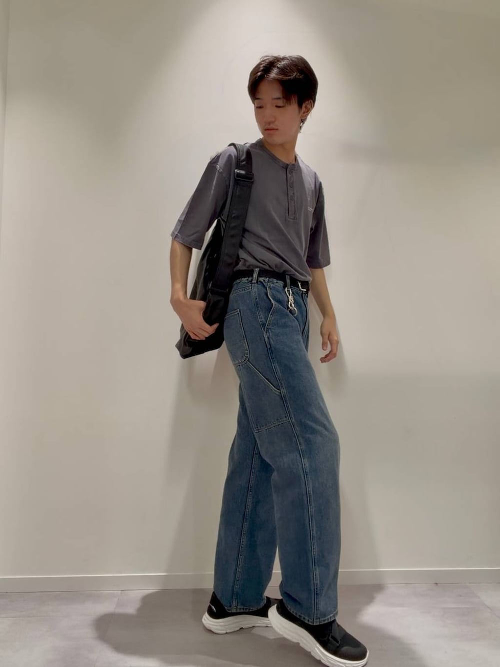 ブラック系のショルダーバッグ、ブラック系のサンダル、ブルー系のデニムパンツを着用したメンズの夏コーディネートの2枚目の写真