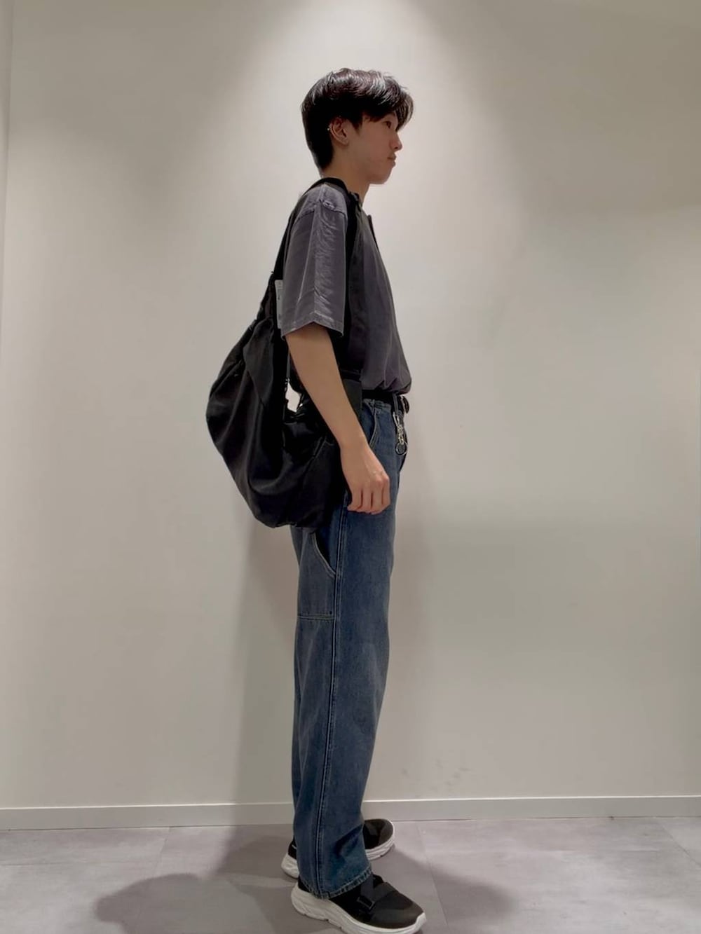ブラック系のショルダーバッグ、ブラック系のサンダル、ブルー系のデニムパンツを着用したメンズの夏コーディネートの5枚目の写真