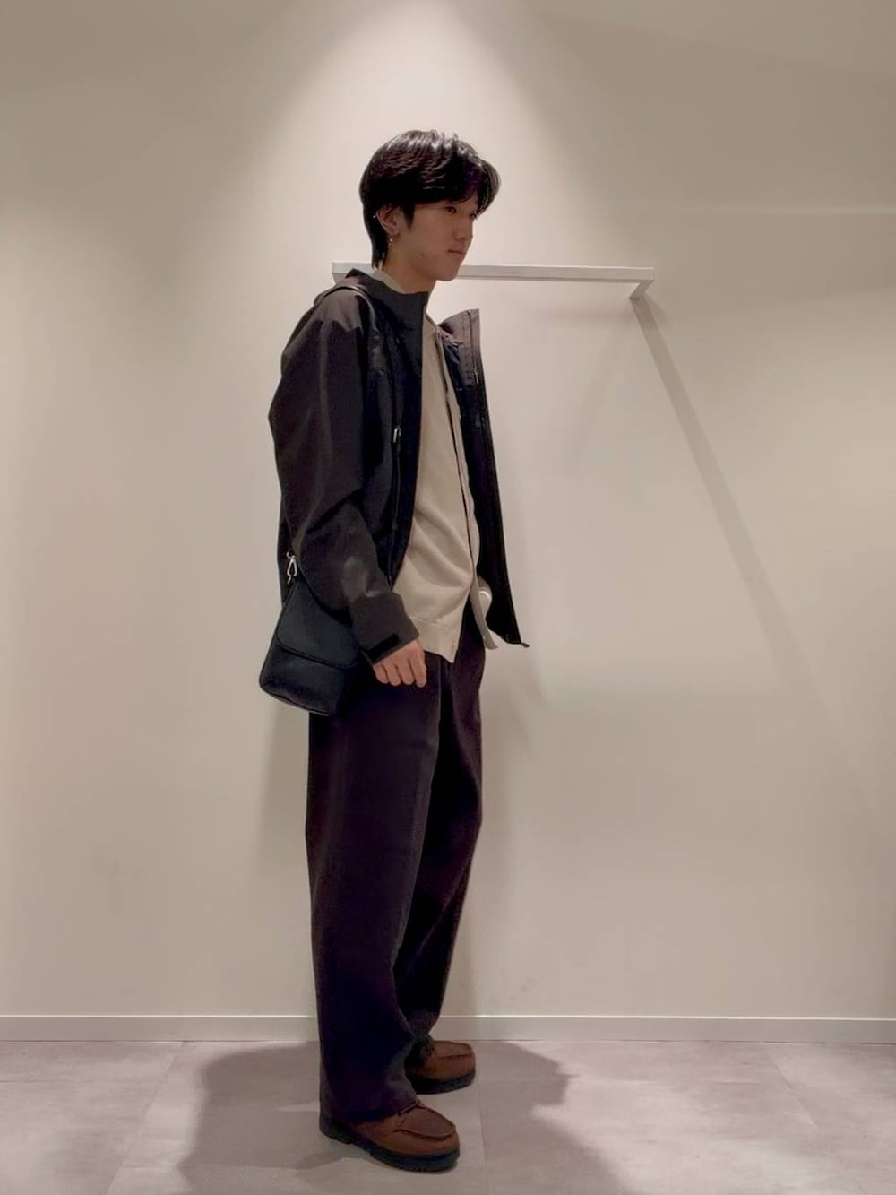 ブラック系のショルダーバッグ、ブラウン系のブルゾン、ベージュ系のカーディガン/ボレロを着用したメンズの秋コーディネートの3枚目の写真
