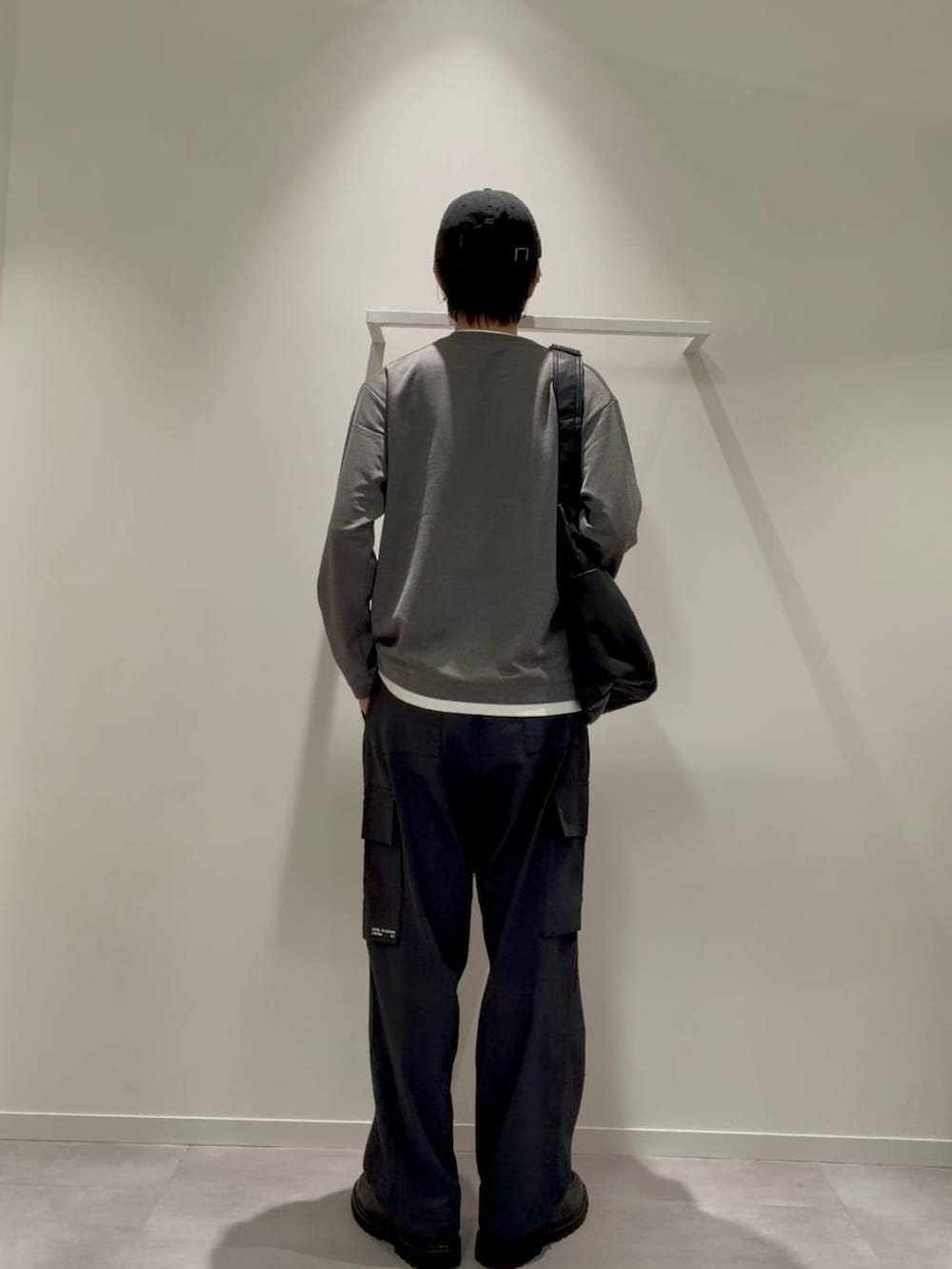 ブラック系のショルダーバッグ、グレー系のその他シューズ、ブルー系のデニムパンツを着用したメンズの秋コーディネートの4枚目の写真