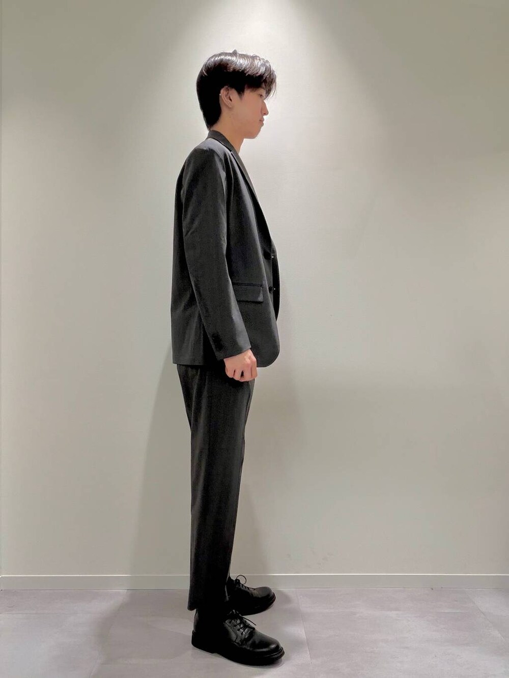 グレー系のスラックス、ブラック系のその他シューズ、ホワイト系のTシャツ/カットソーを着用したメンズの夏コーディネートの4枚目の写真