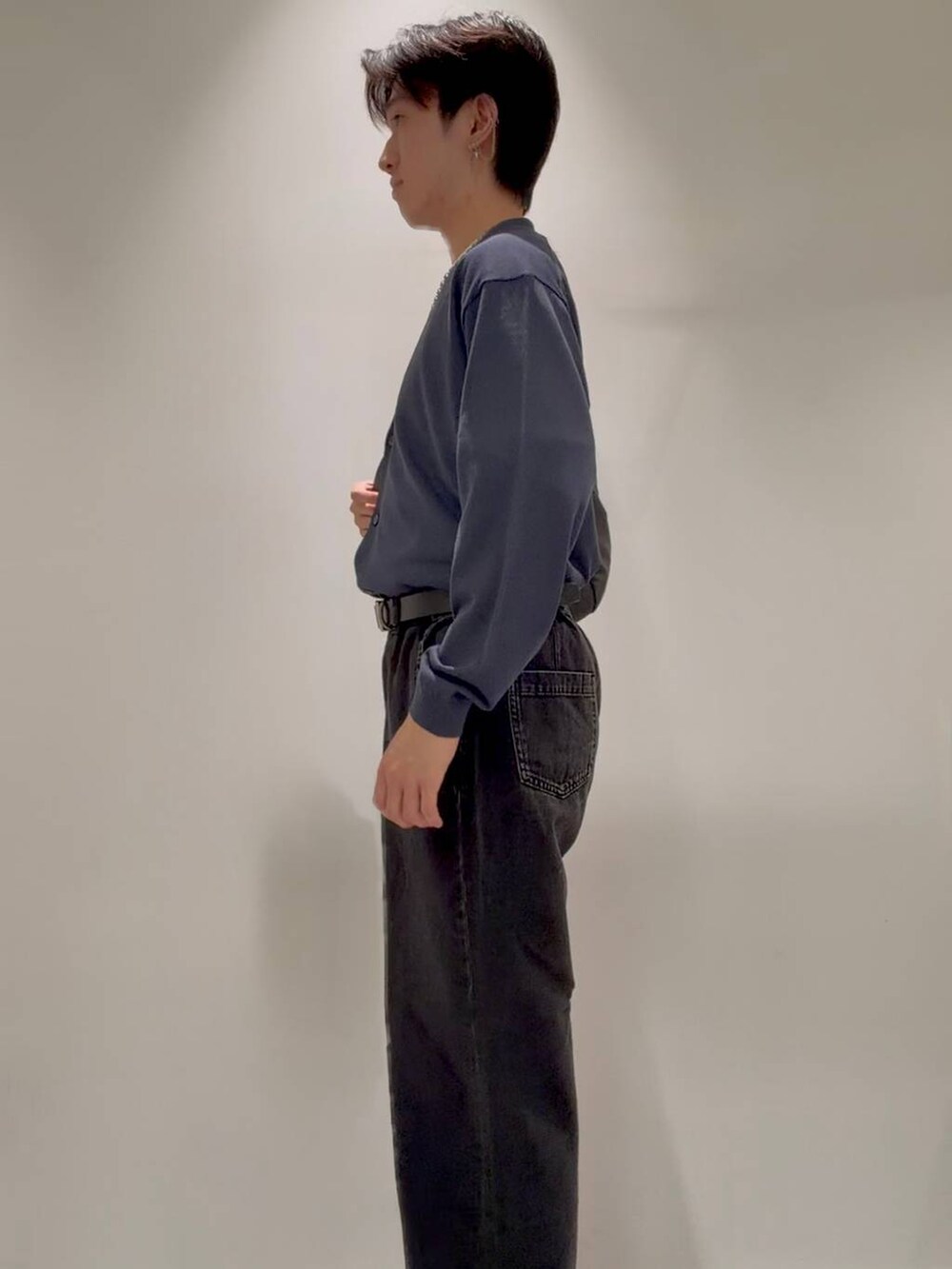 ブラック系のデニムパンツ、グレー系のその他シューズ、ホワイト系のTシャツ/カットソーを着用したメンズの秋コーディネートの2枚目の写真
