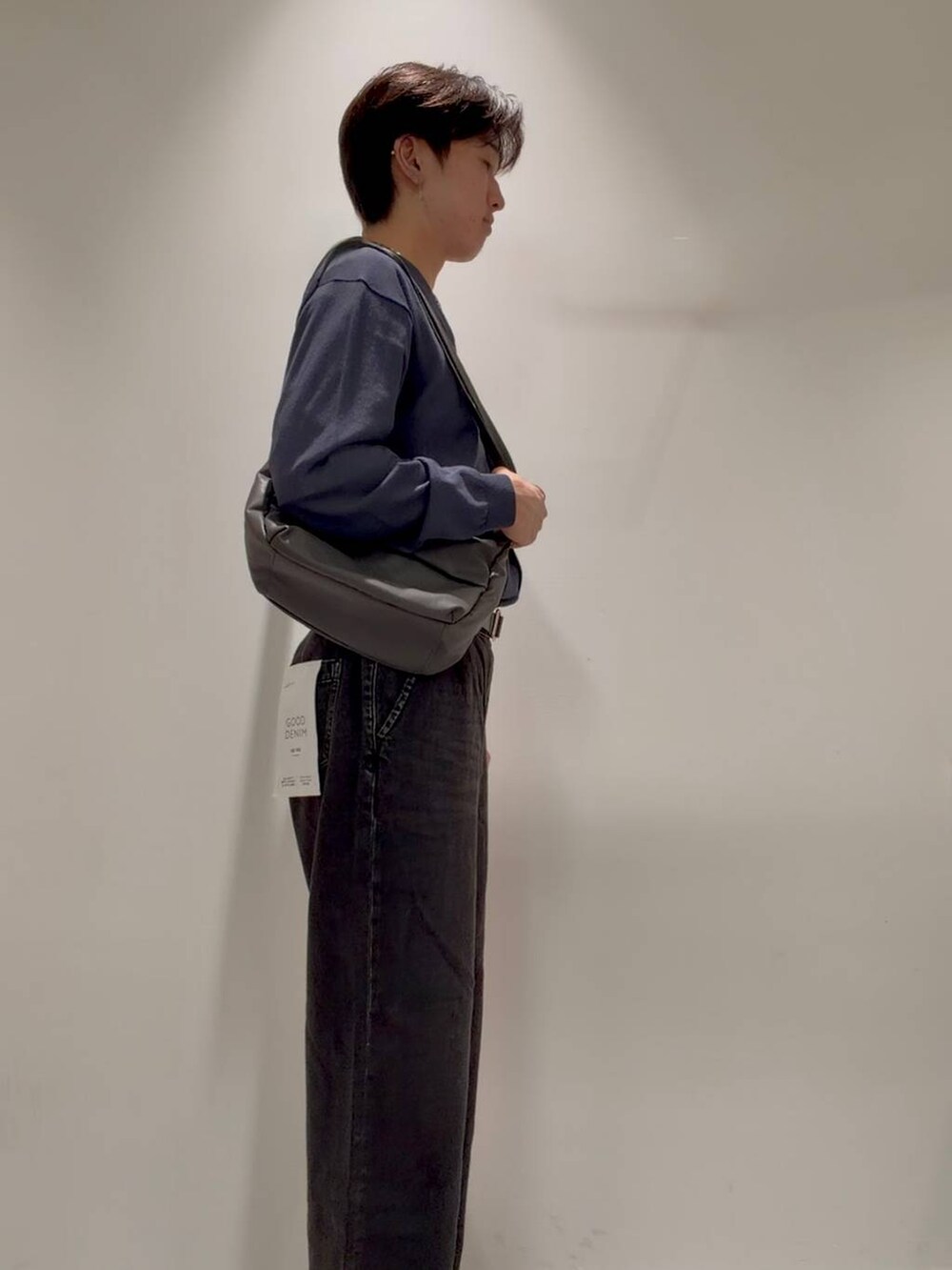 ブラック系のデニムパンツ、グレー系のその他シューズ、ホワイト系のTシャツ/カットソーを着用したメンズの秋コーディネートの4枚目の写真