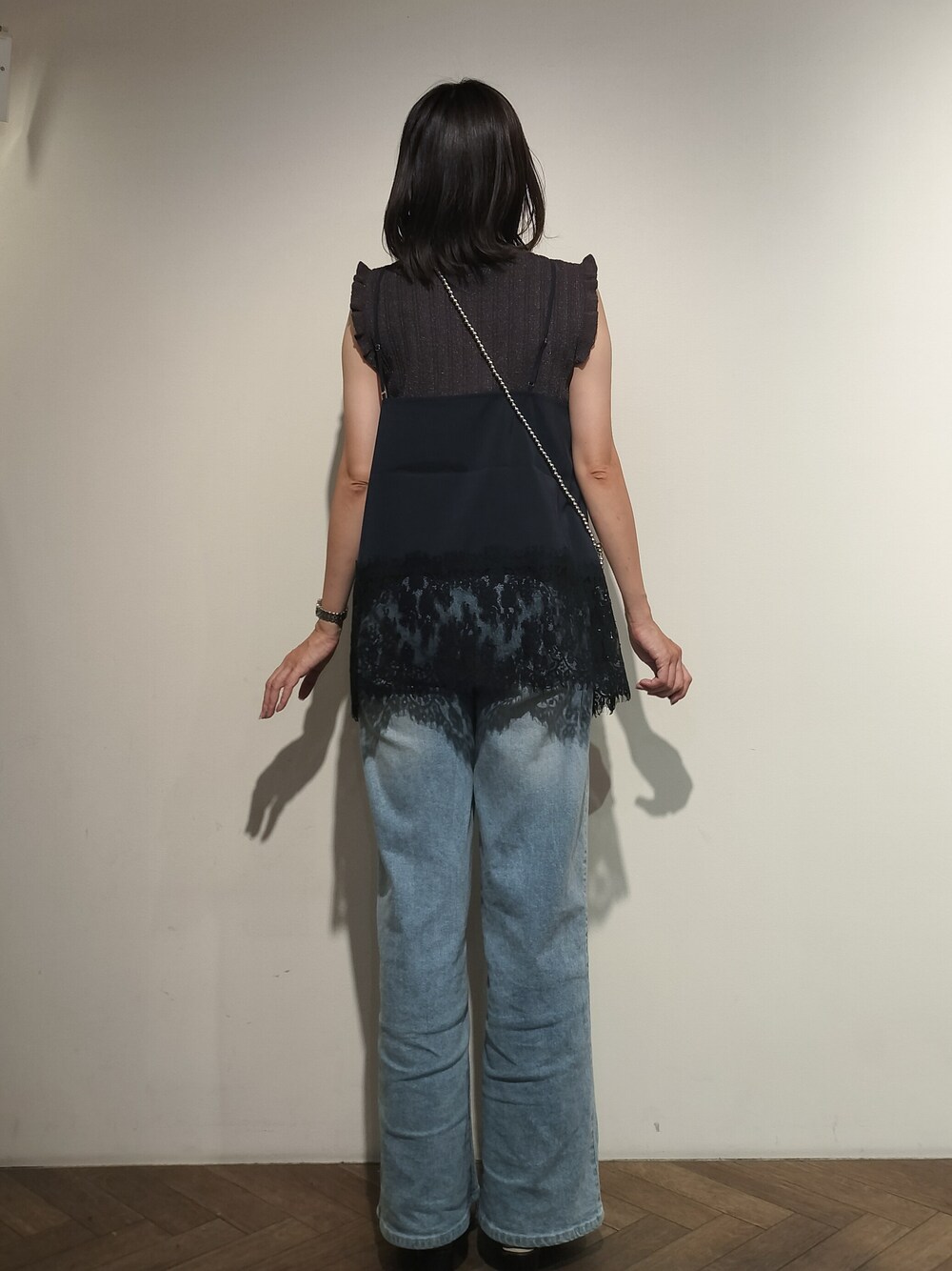 グレー系のニット/セーター、ブルー系のシャツ/ブラウス、ブルー系のデニムパンツを着用したレディースの夏コーディネートの5枚目の写真