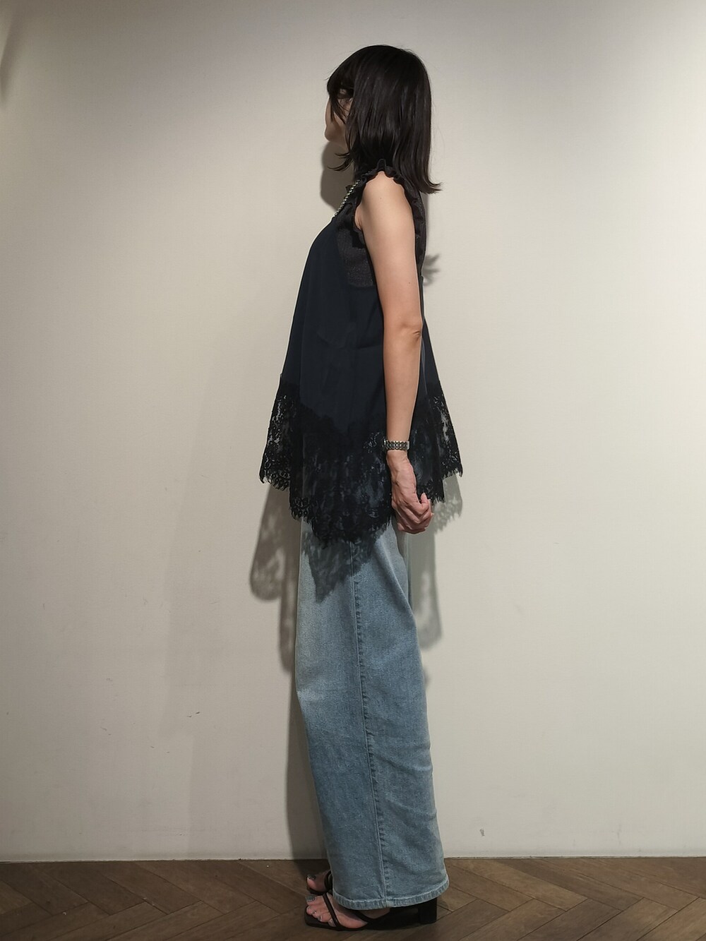 グレー系のニット/セーター、ブルー系のシャツ/ブラウス、ブルー系のデニムパンツを着用したレディースの夏コーディネートの3枚目の写真