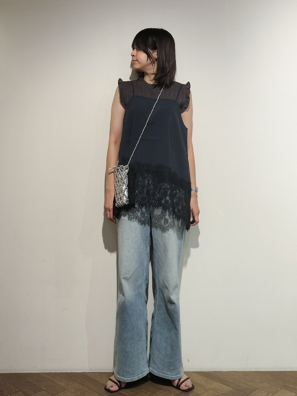 グレー系のニット/セーター、ブルー系のシャツ/ブラウス、ブルー系のデニムパンツを着用したレディースの夏コーディネートの6枚目の写真