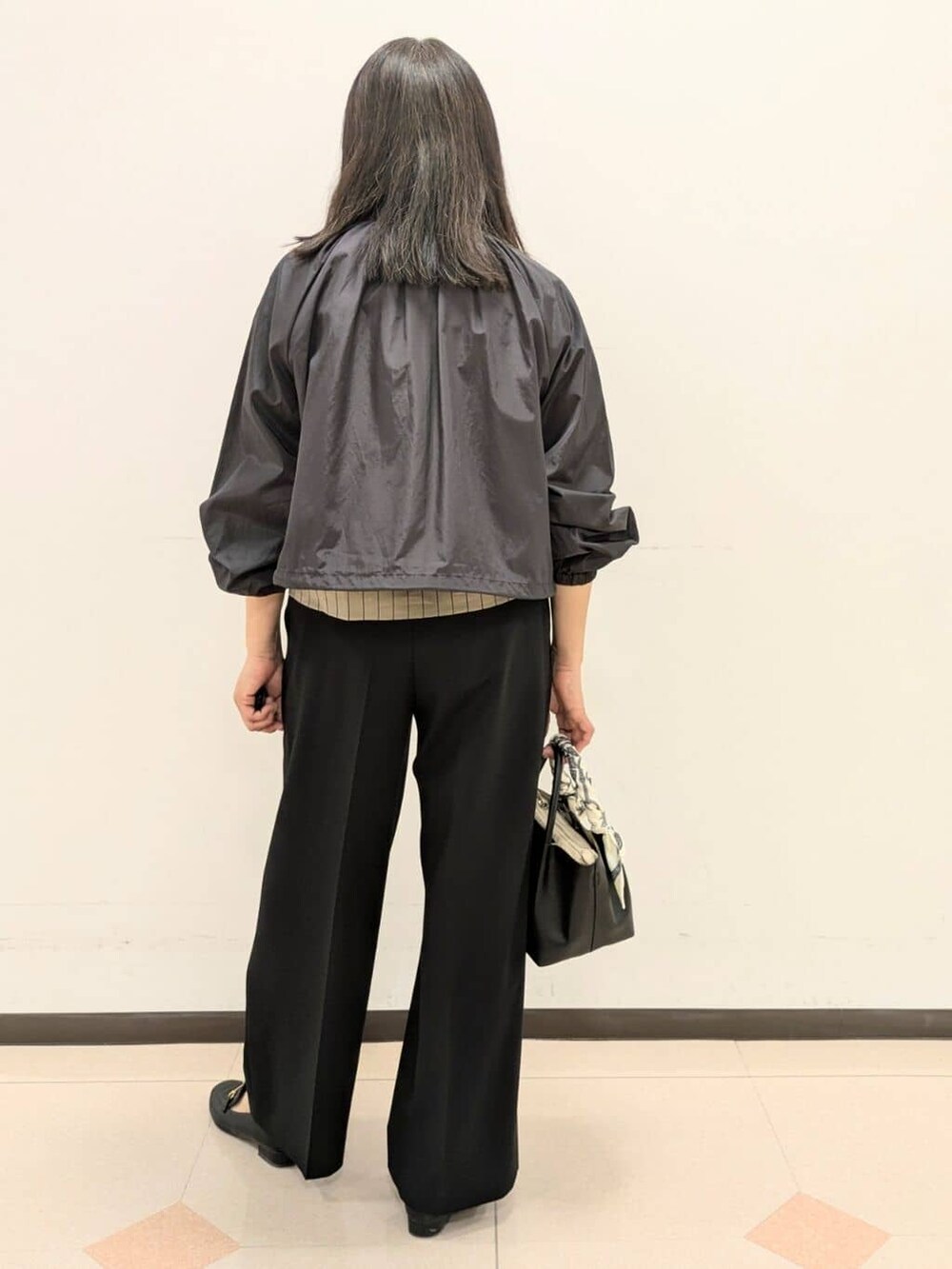 ベージュ系のシャツ/ブラウス、ブラック系のブルゾン、ブラック系のトートバッグを着用したレディースの春コーディネートの6枚目の写真