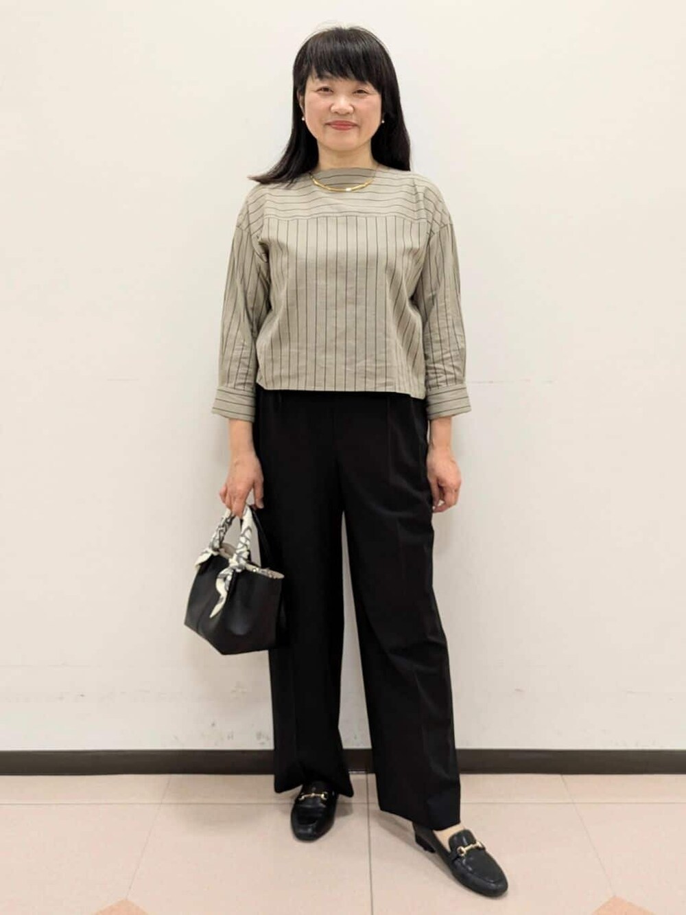 ベージュ系のシャツ/ブラウス、ブラック系のブルゾン、ブラック系のトートバッグを着用したレディースの春コーディネートの7枚目の写真