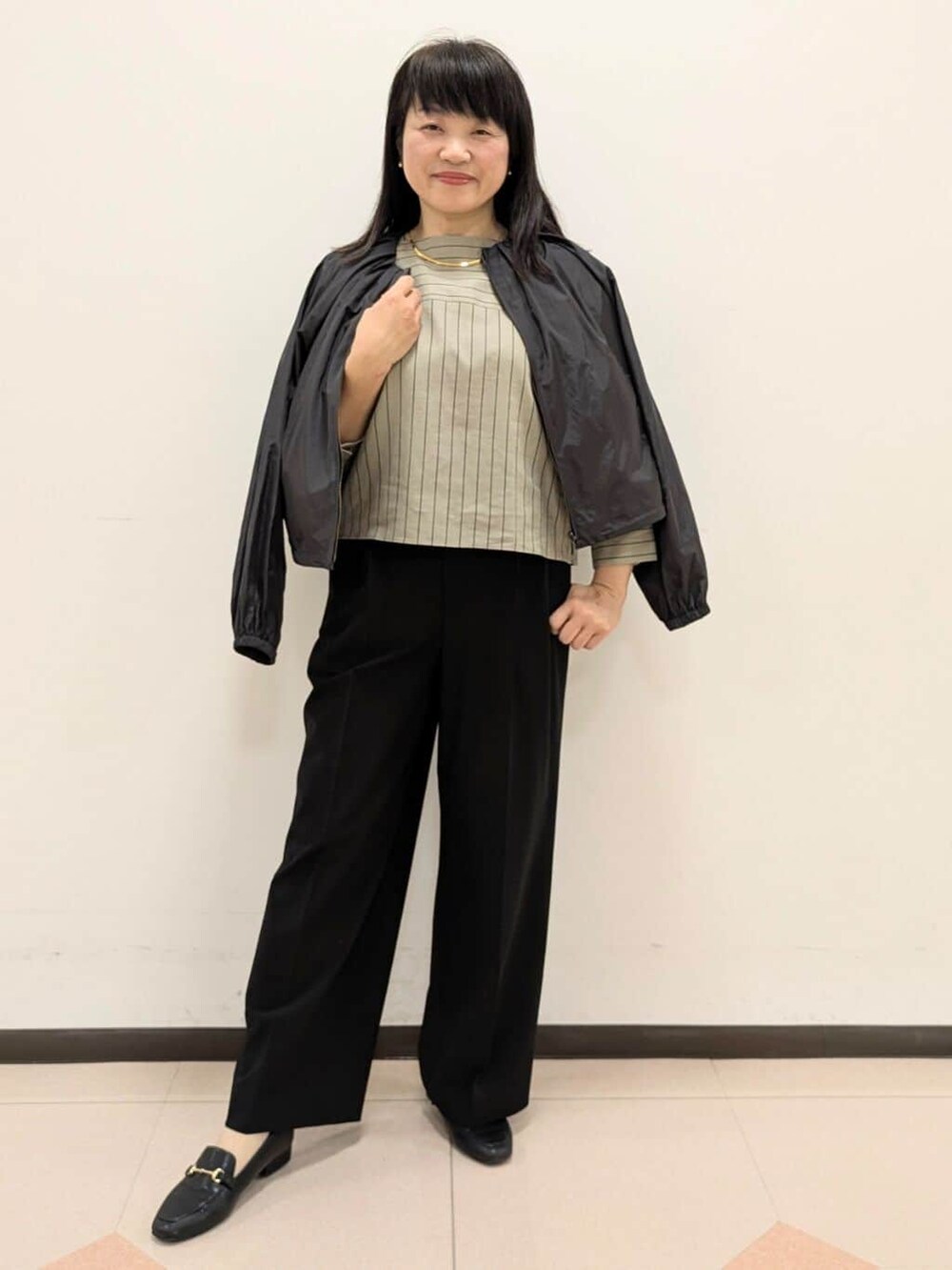 ベージュ系のシャツ/ブラウス、ブラック系のブルゾン、ブラック系のトートバッグを着用したレディースの春コーディネートの4枚目の写真
