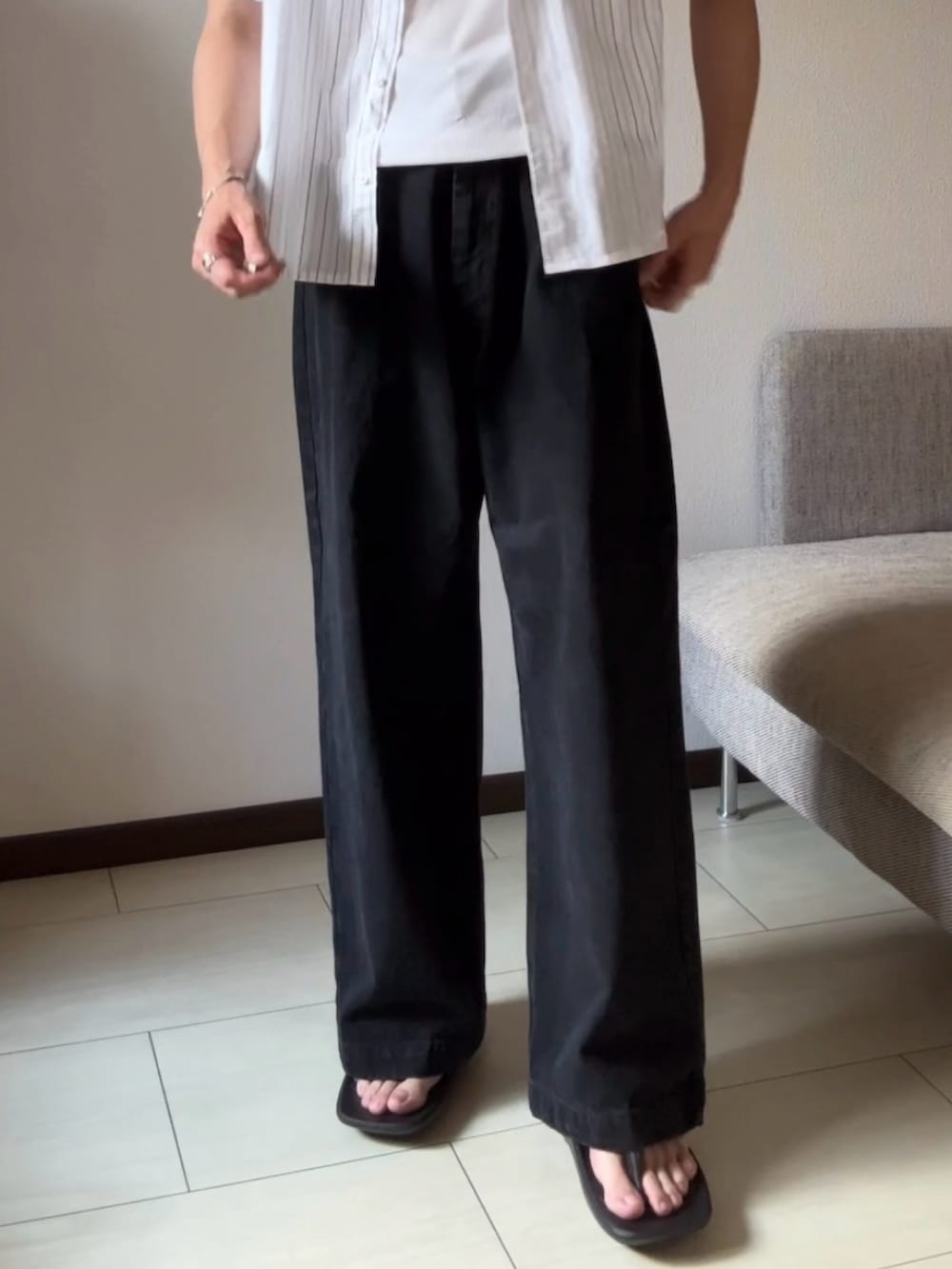 ブラック系のデニムパンツ、ブラック系のサンダル、ホワイト系のシャツ/ブラウスを着用したメンズの夏コーディネートの2枚目の写真