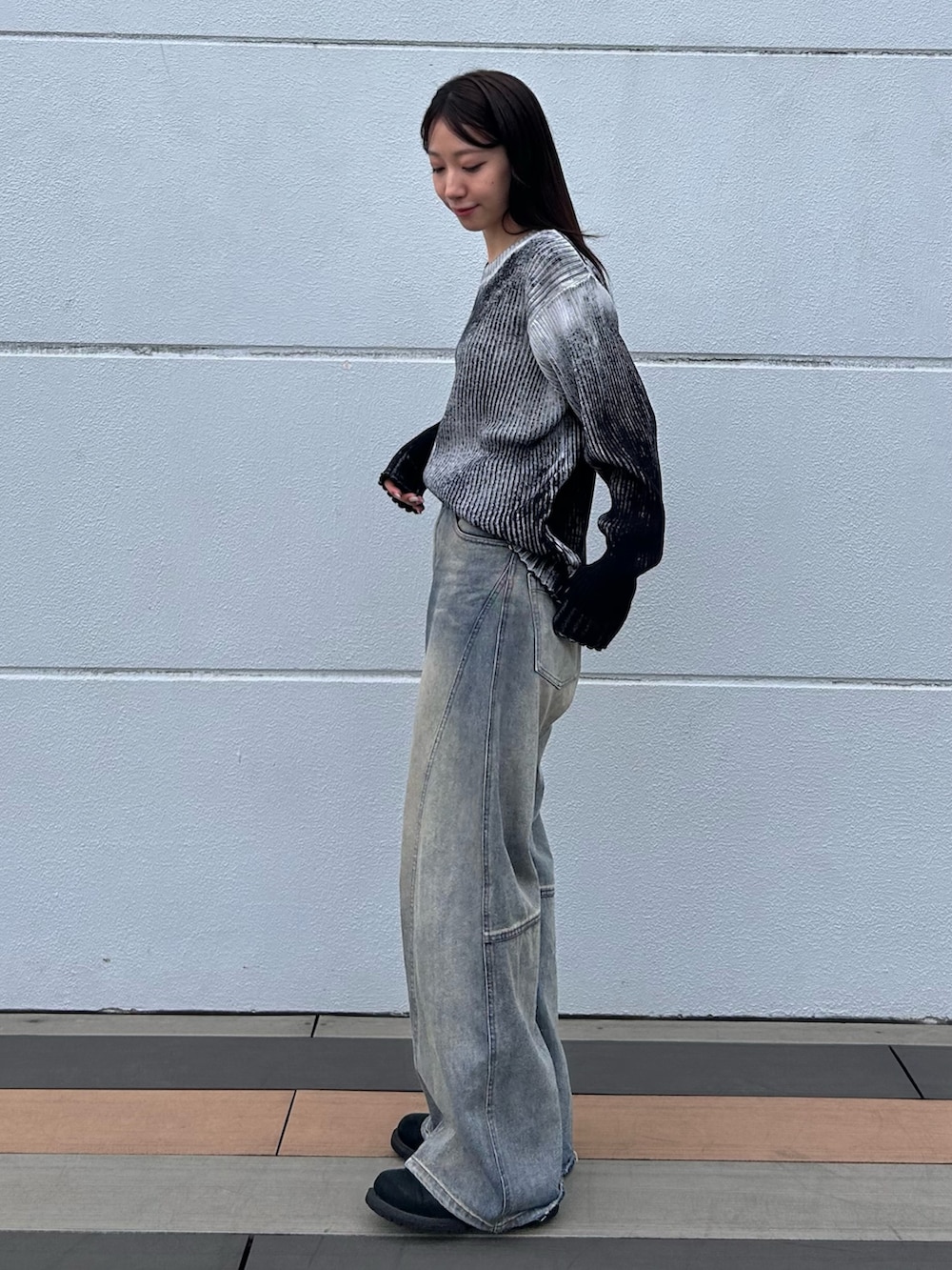 ブルー系のデニムパンツ、ホワイト系のニット/セーター、ブラック系のベルトを着用したレディースの秋コーディネートの4枚目の写真