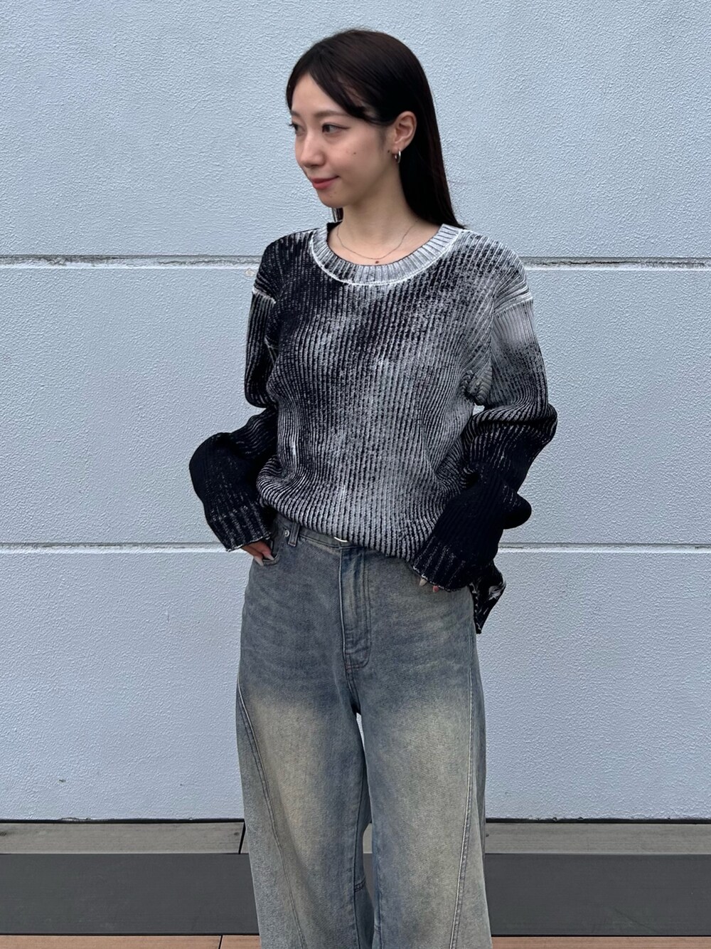 ブルー系のデニムパンツ、ホワイト系のニット/セーター、ブラック系のベルトを着用したレディースの秋コーディネートの7枚目の写真