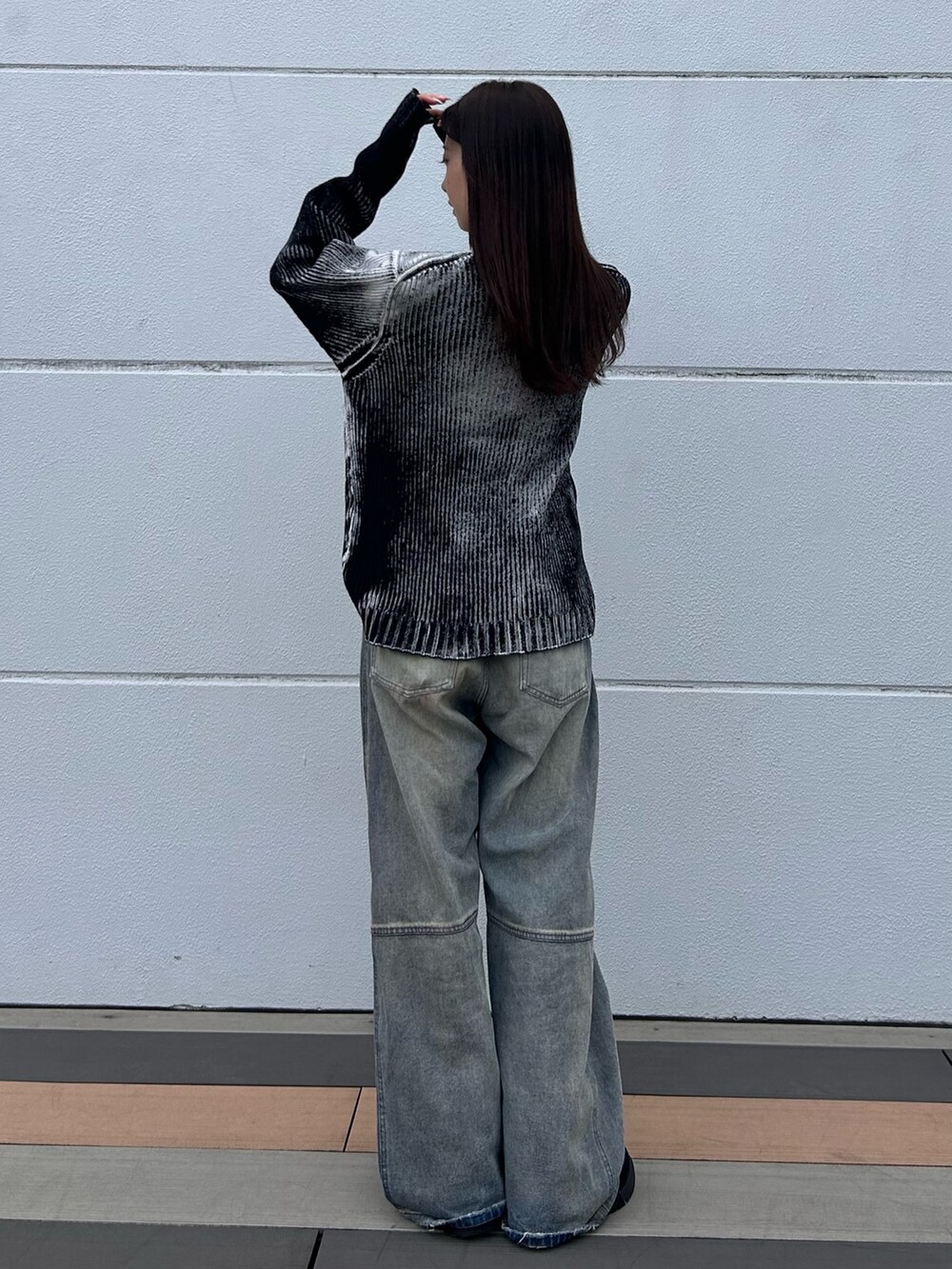 ブルー系のデニムパンツ、ホワイト系のニット/セーター、ブラック系のベルトを着用したレディースの秋コーディネートの5枚目の写真